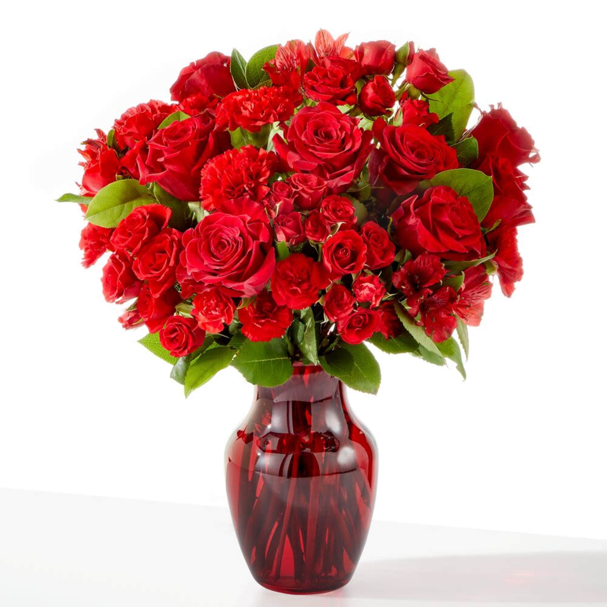 Red roses and carnations in a red glass vase
