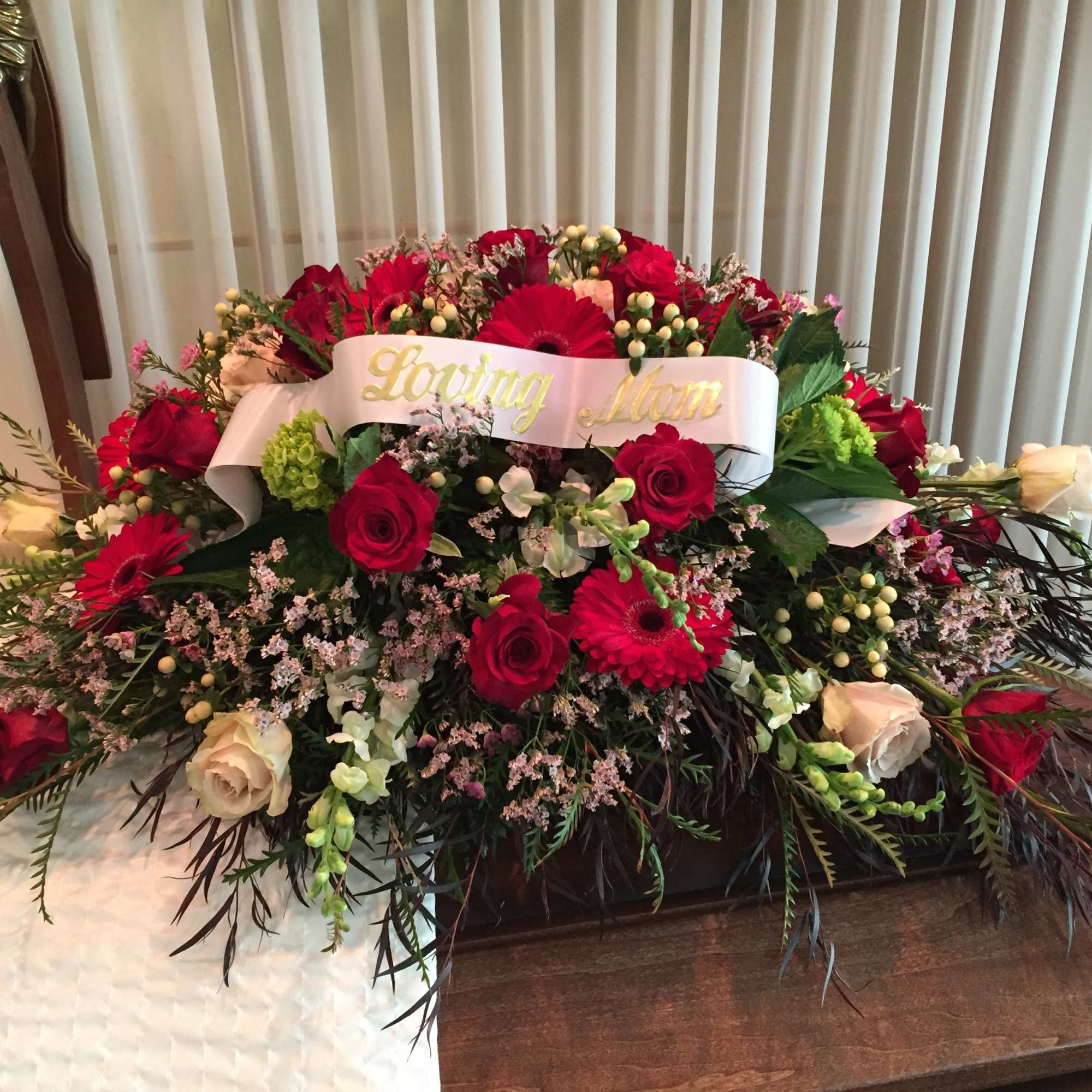 Large red and white floral spray with a "Loving Mom" ribbon