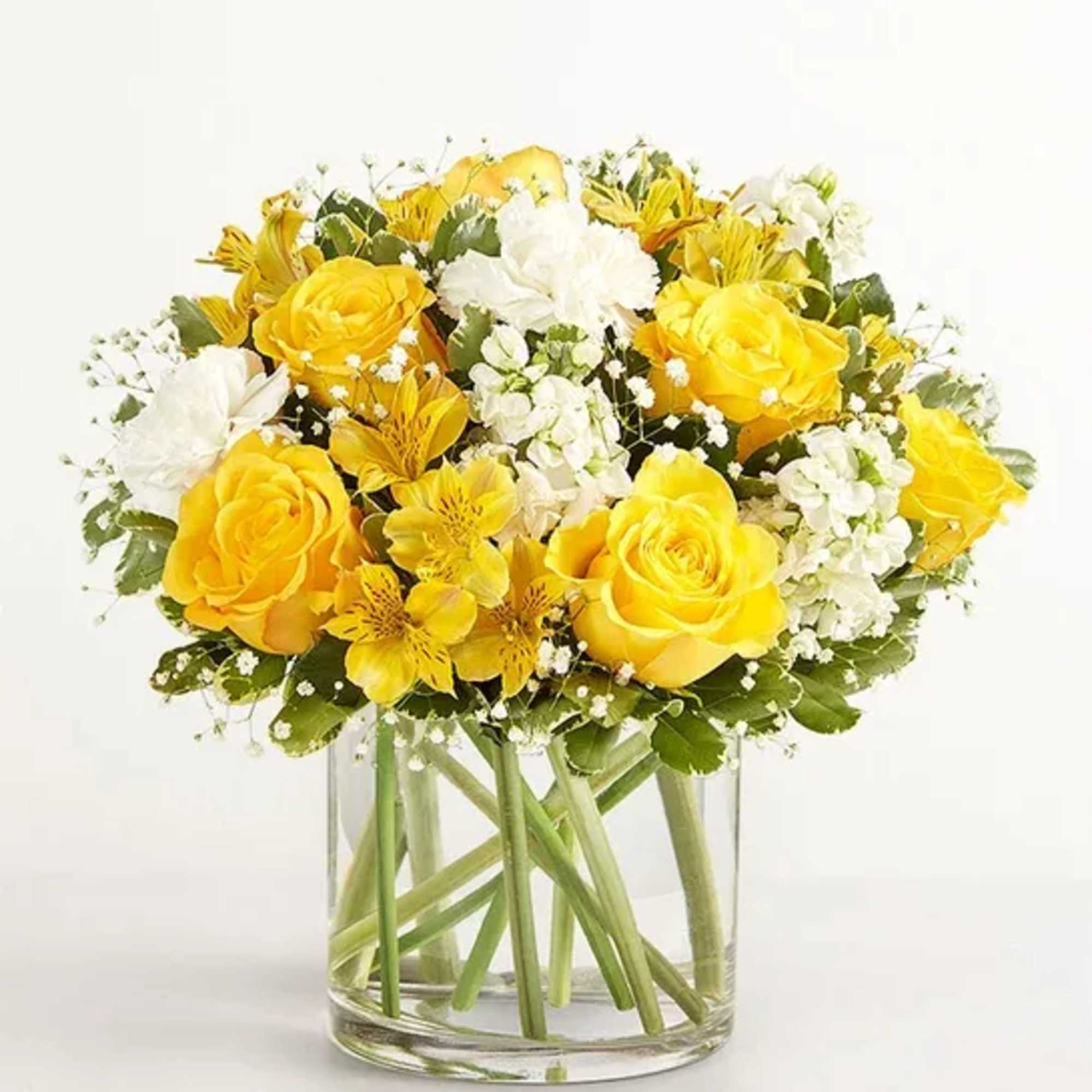 Yellow and white flower bouquet in a clear glass vase
