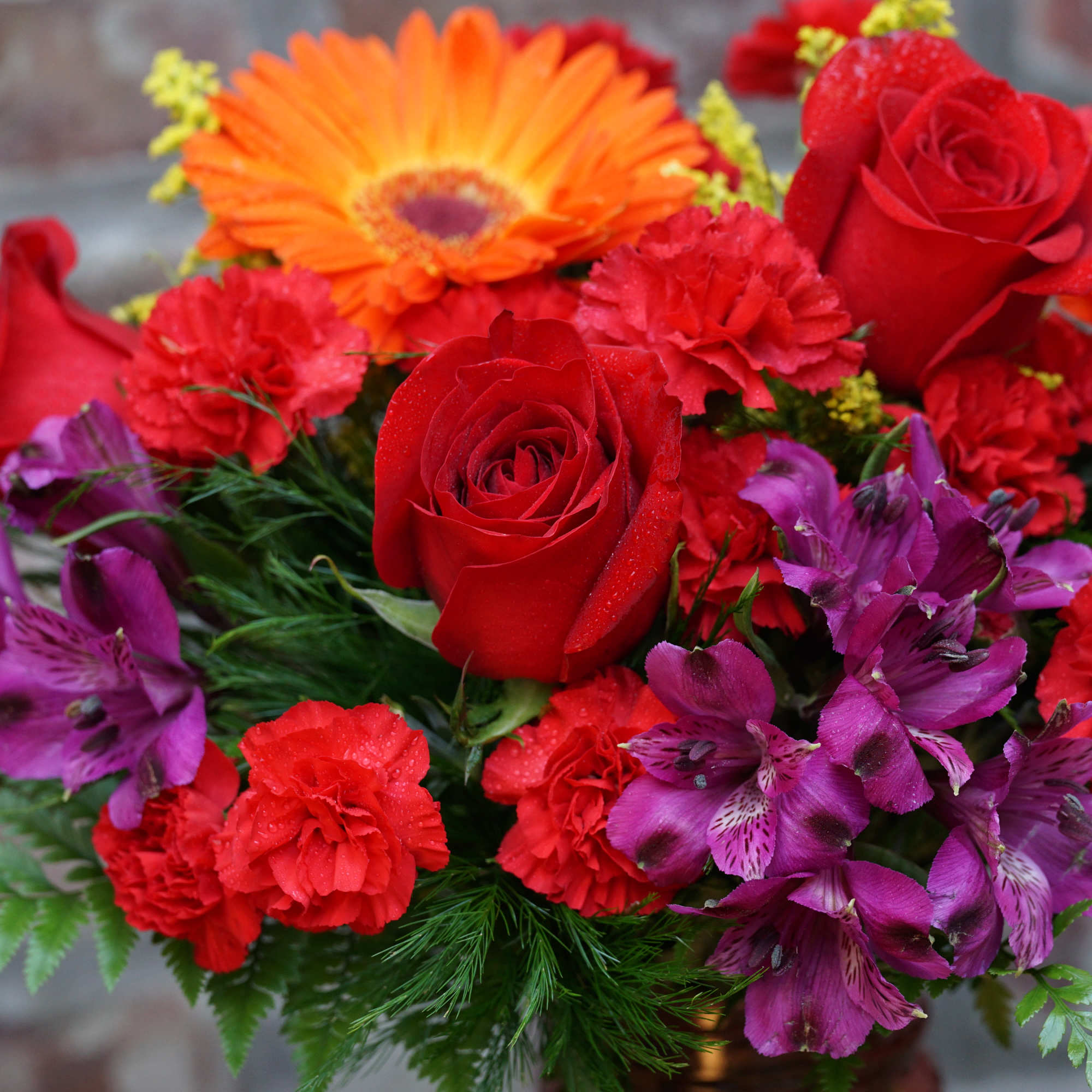 Bouquet of red roses, carnations, and purple flowers