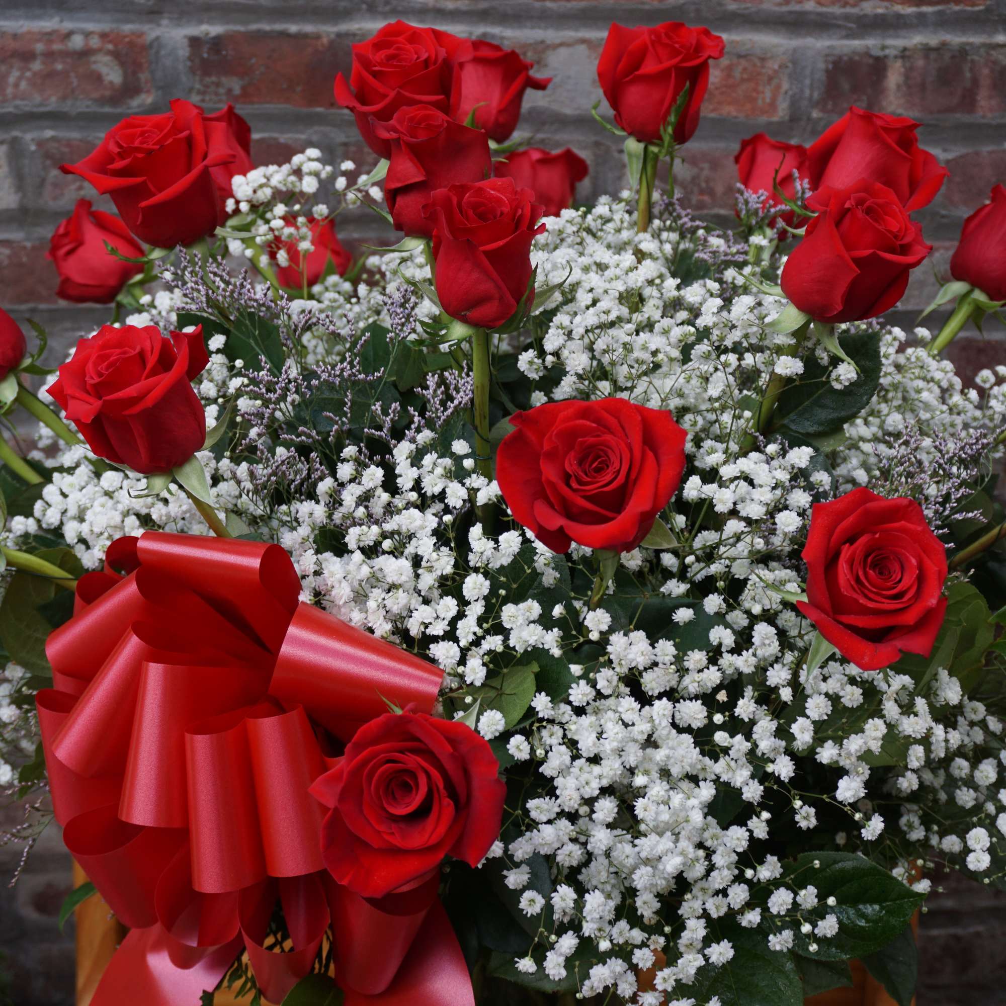 Bouquet of red roses with white baby's breath and a red ribbon bow