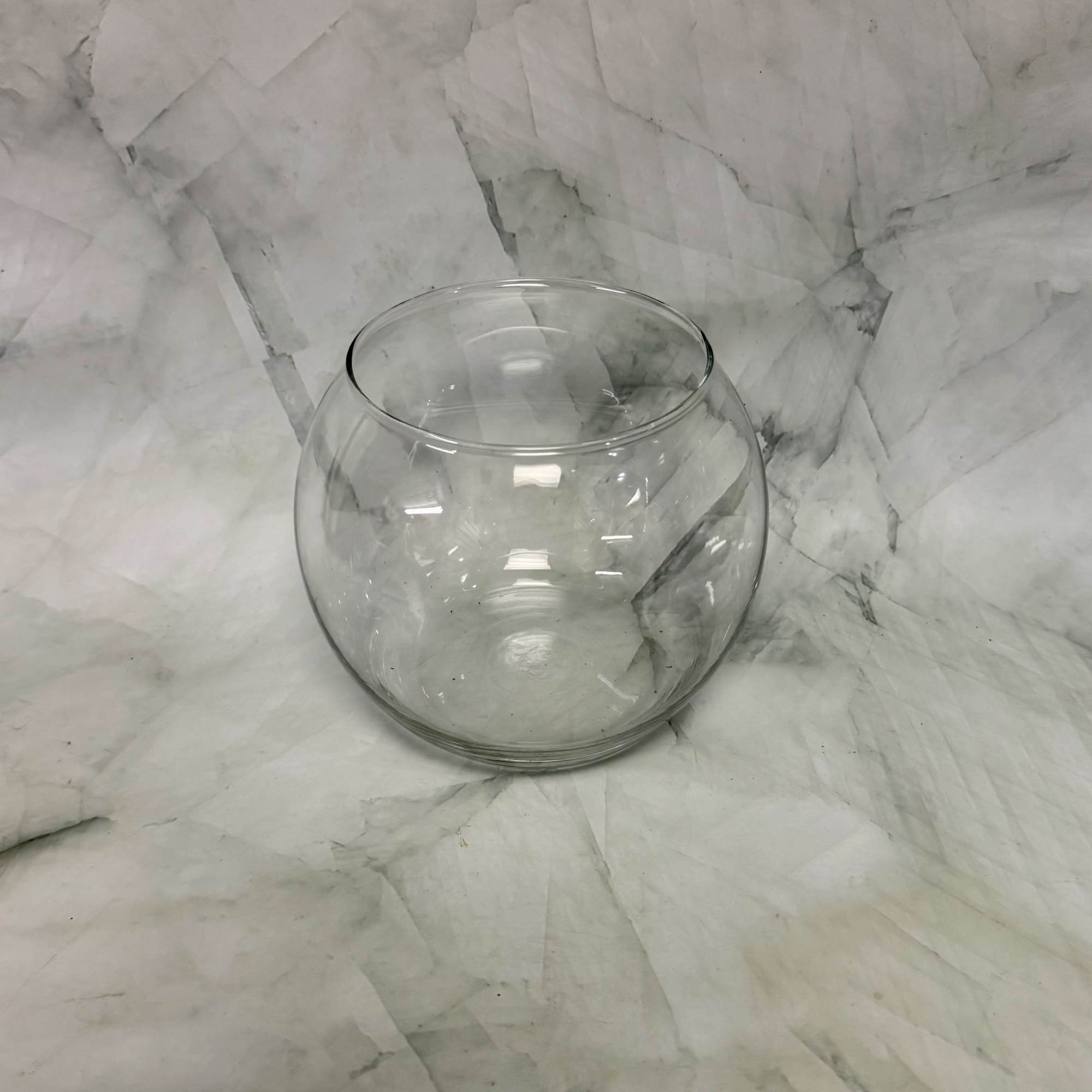 Clear round glass bowl vase on a marble surface