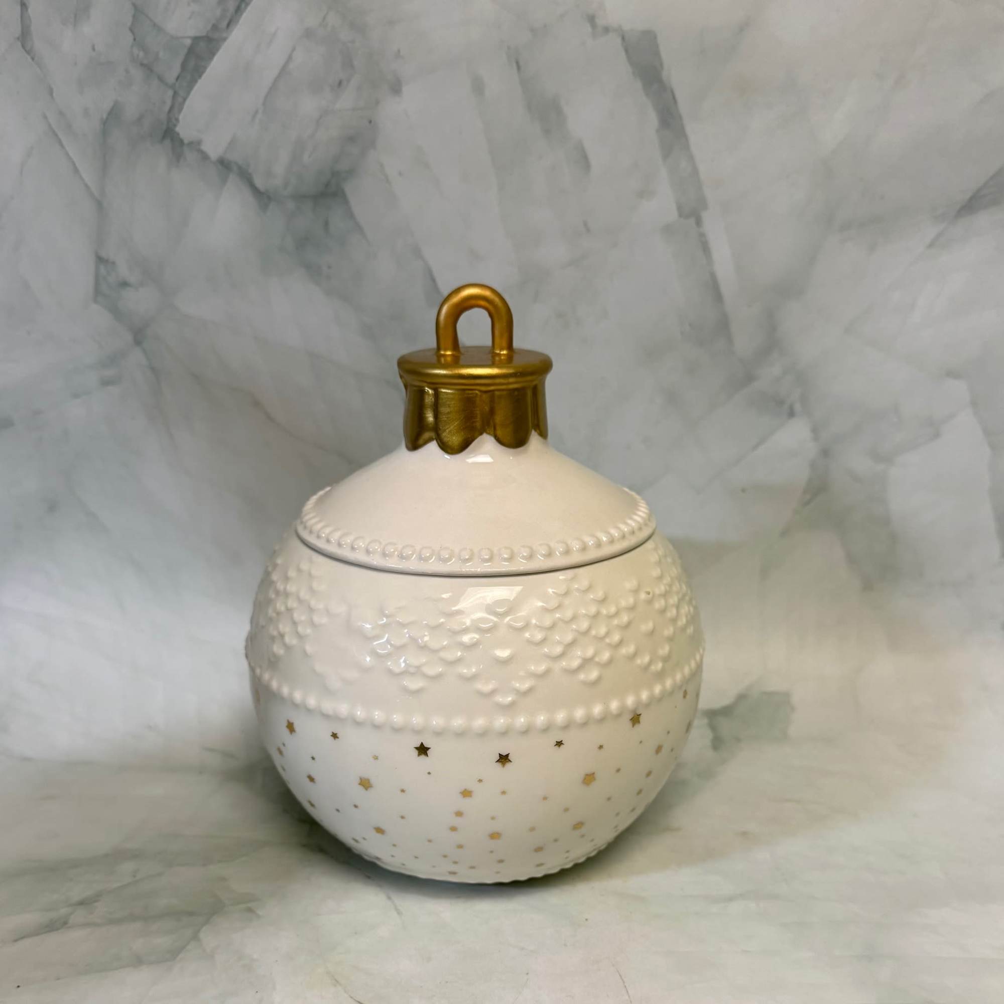 White decorative ceramic jar with gold lid and star accents