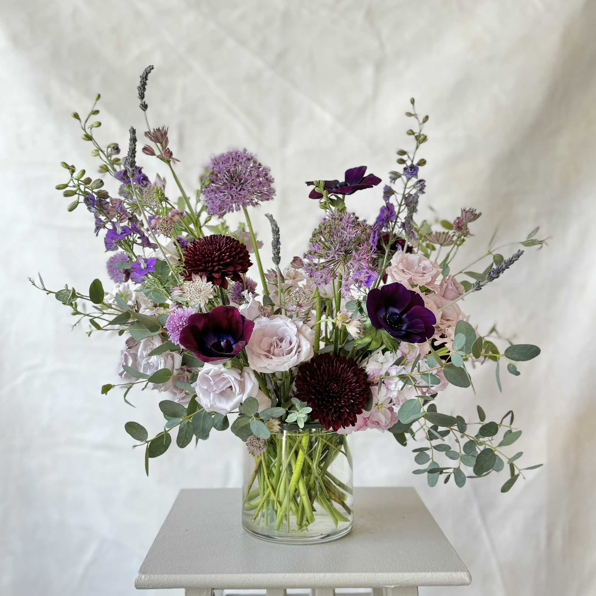 The Amethyst Arrangement features a balanced mix of soft lavender and deep