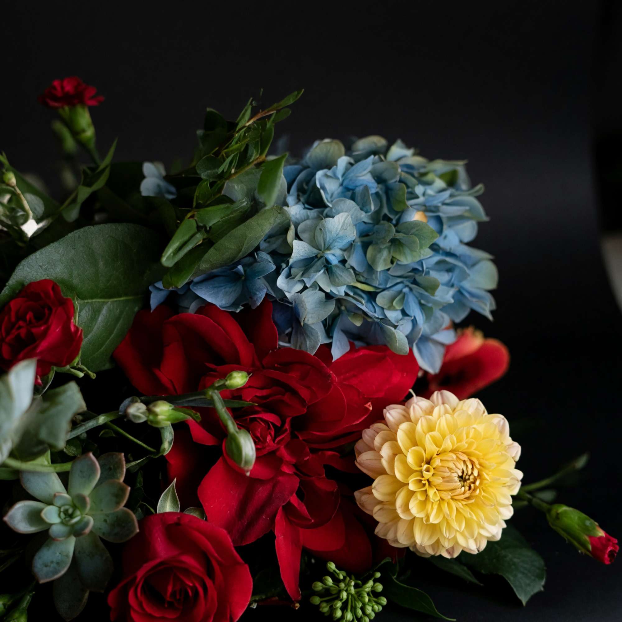 Gift card with a floral arrangement of red roses, blue hydrangea, and a yellow dahlia