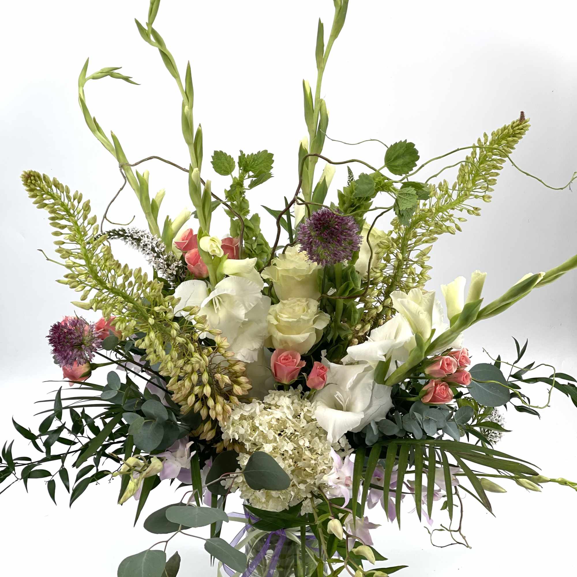 Tall mixed bouquet in a glass vase with white, pink, and purple flowers