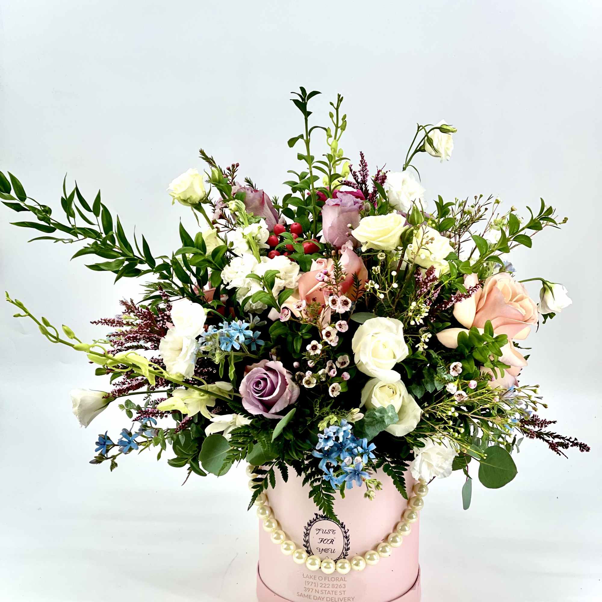 Mixed pastel bouquet in a pink hatbox with a pearl handle
