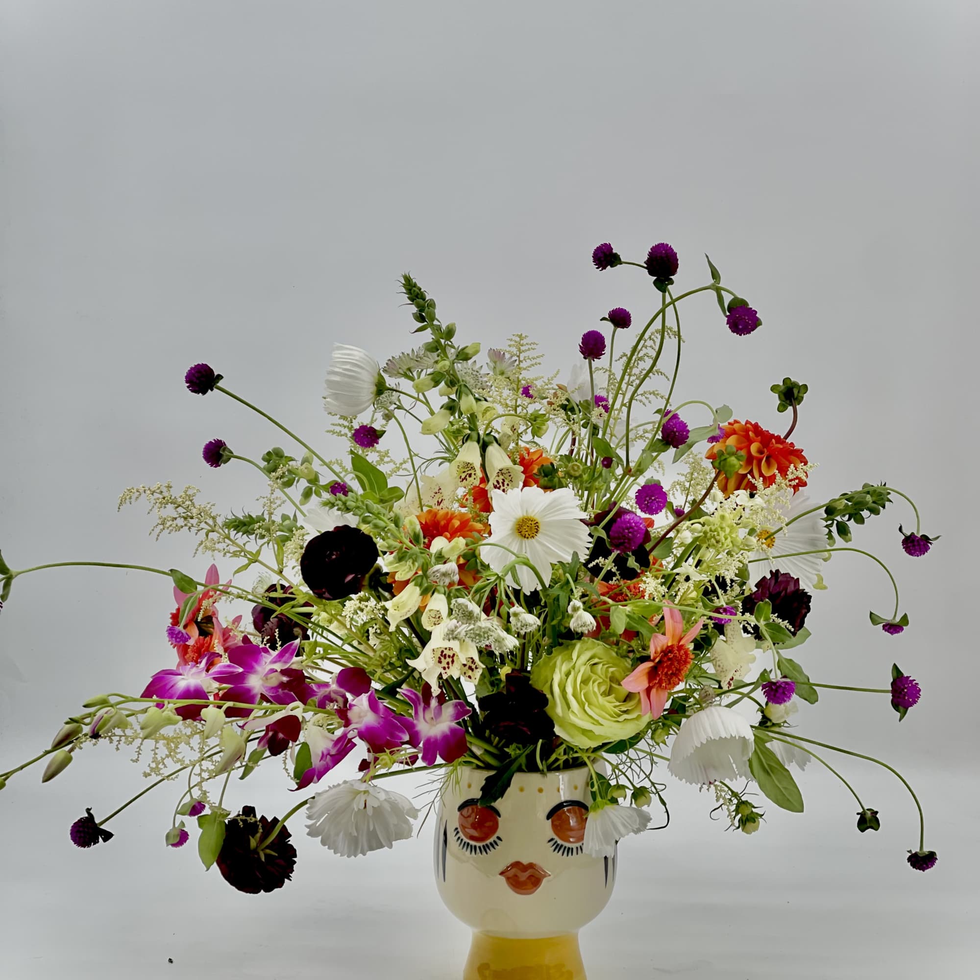 Colorful mixed bouquet in a face-shaped ceramic vase