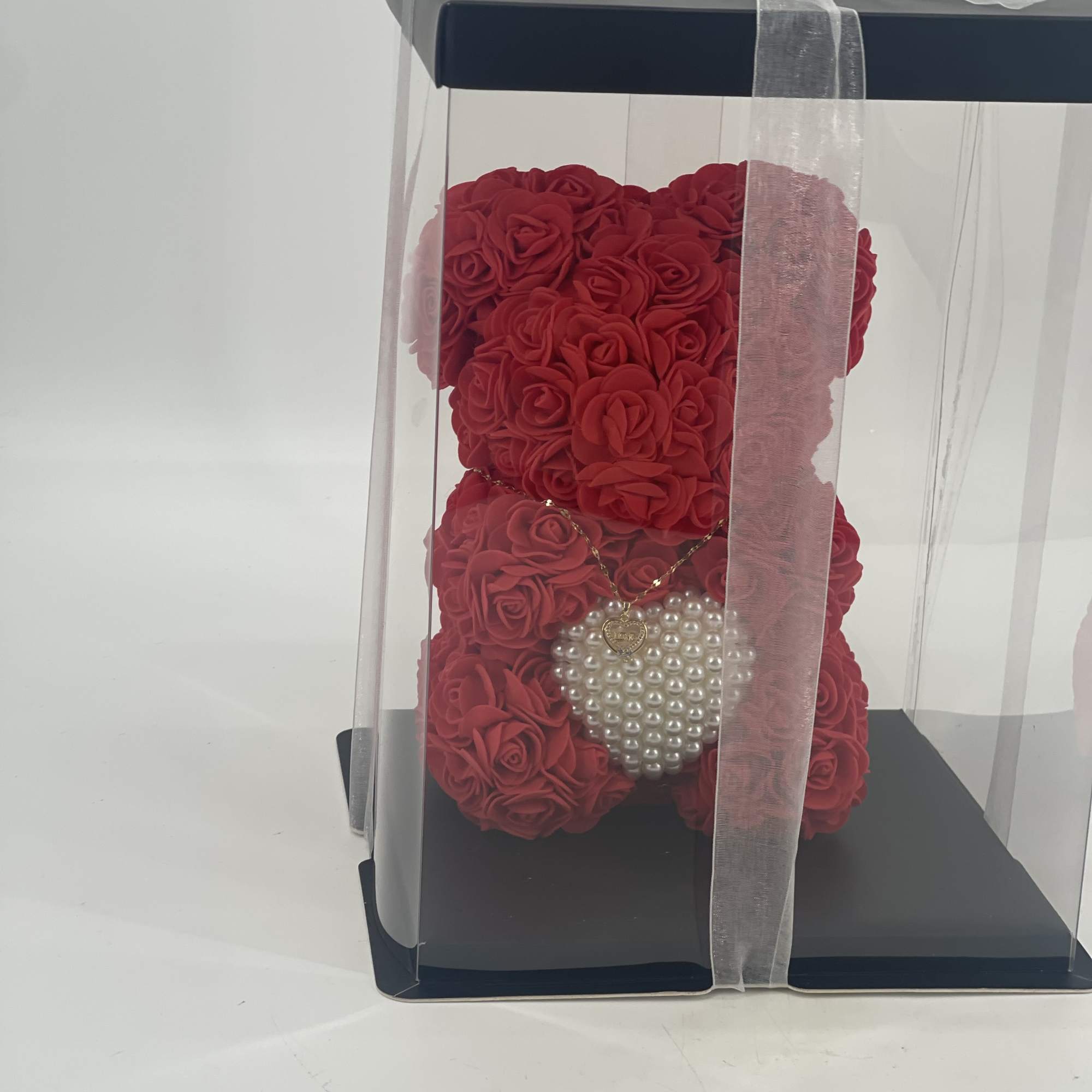 Red rose teddy bear in a clear gift box with a ribbon