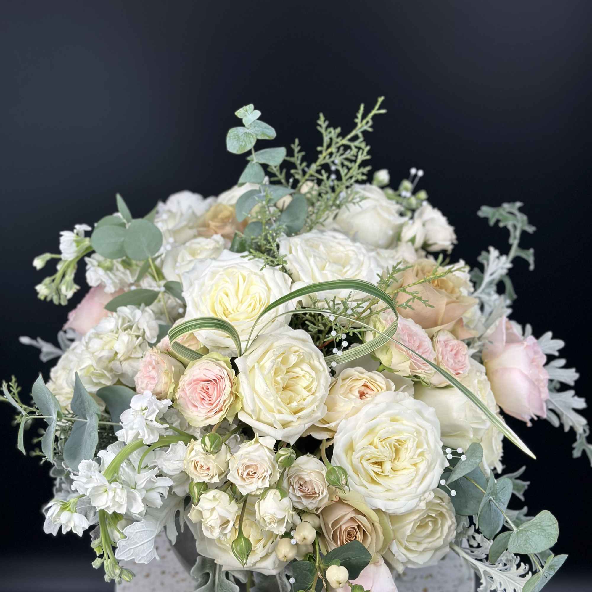 Cream and blush rose bouquet in a speckled round vase