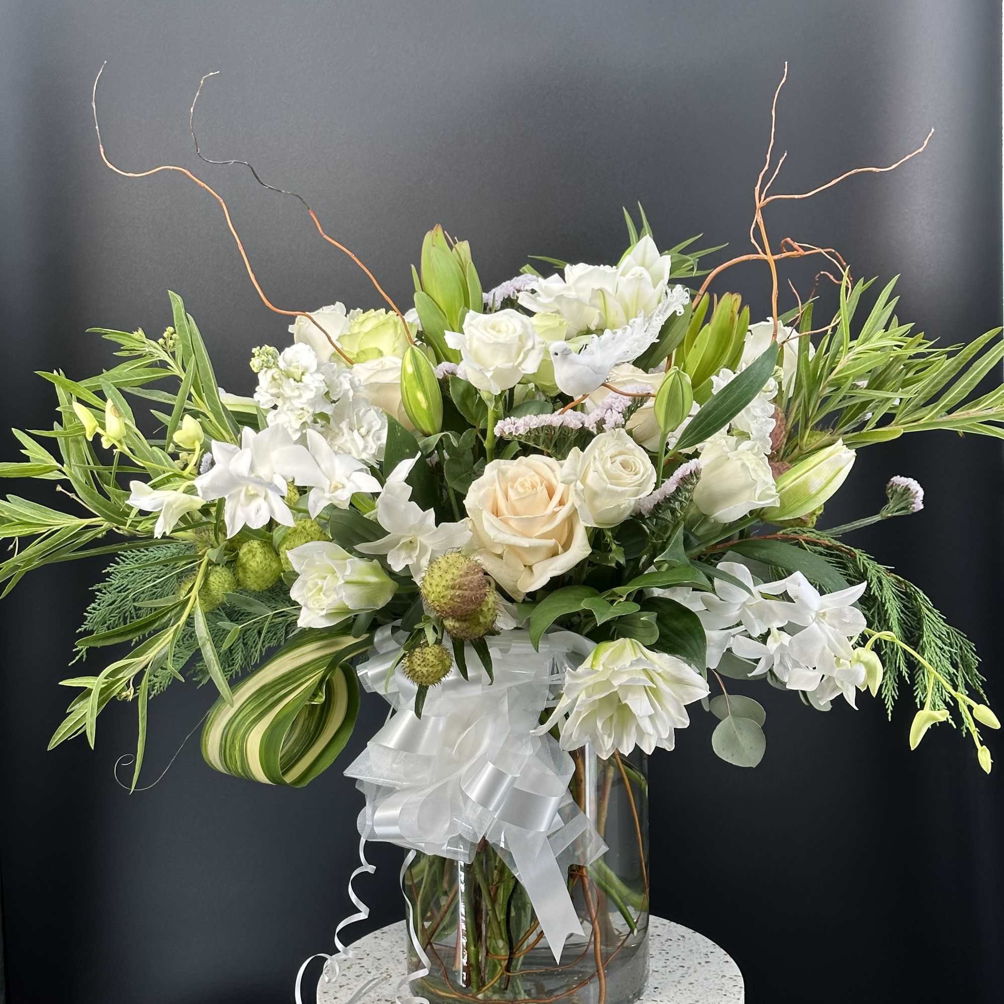 White and cream floral arrangement in a glass vase with a white ribbon, photo 6 of 9