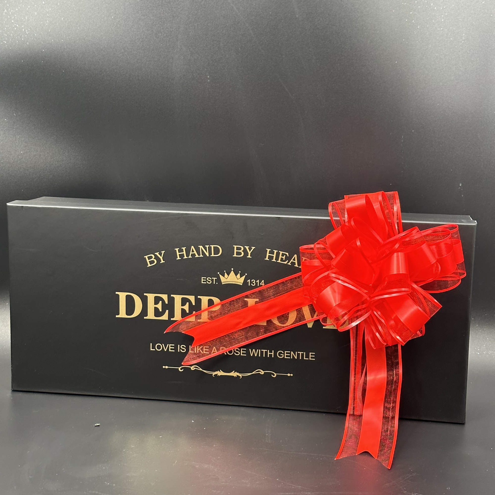 Black gift box with a large red ribbon bow