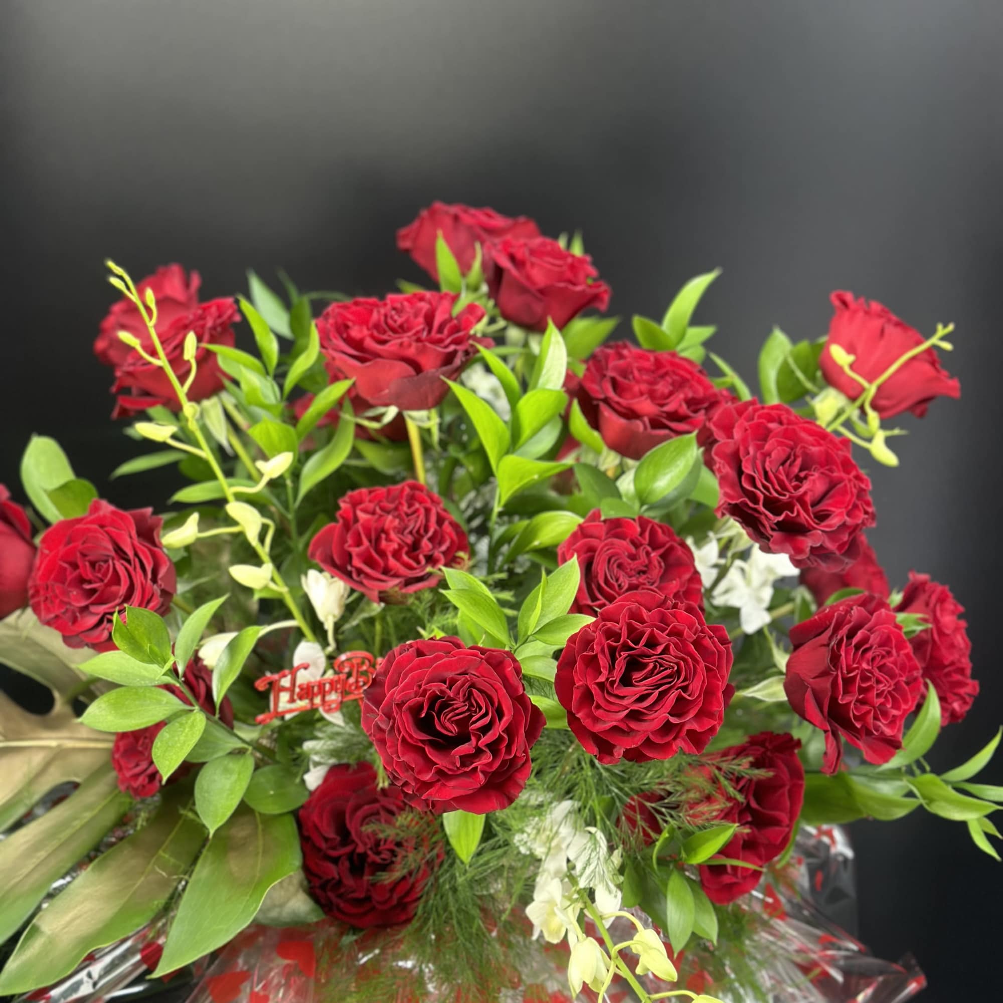 Bouquet of red roses with green foliage and clear wrap