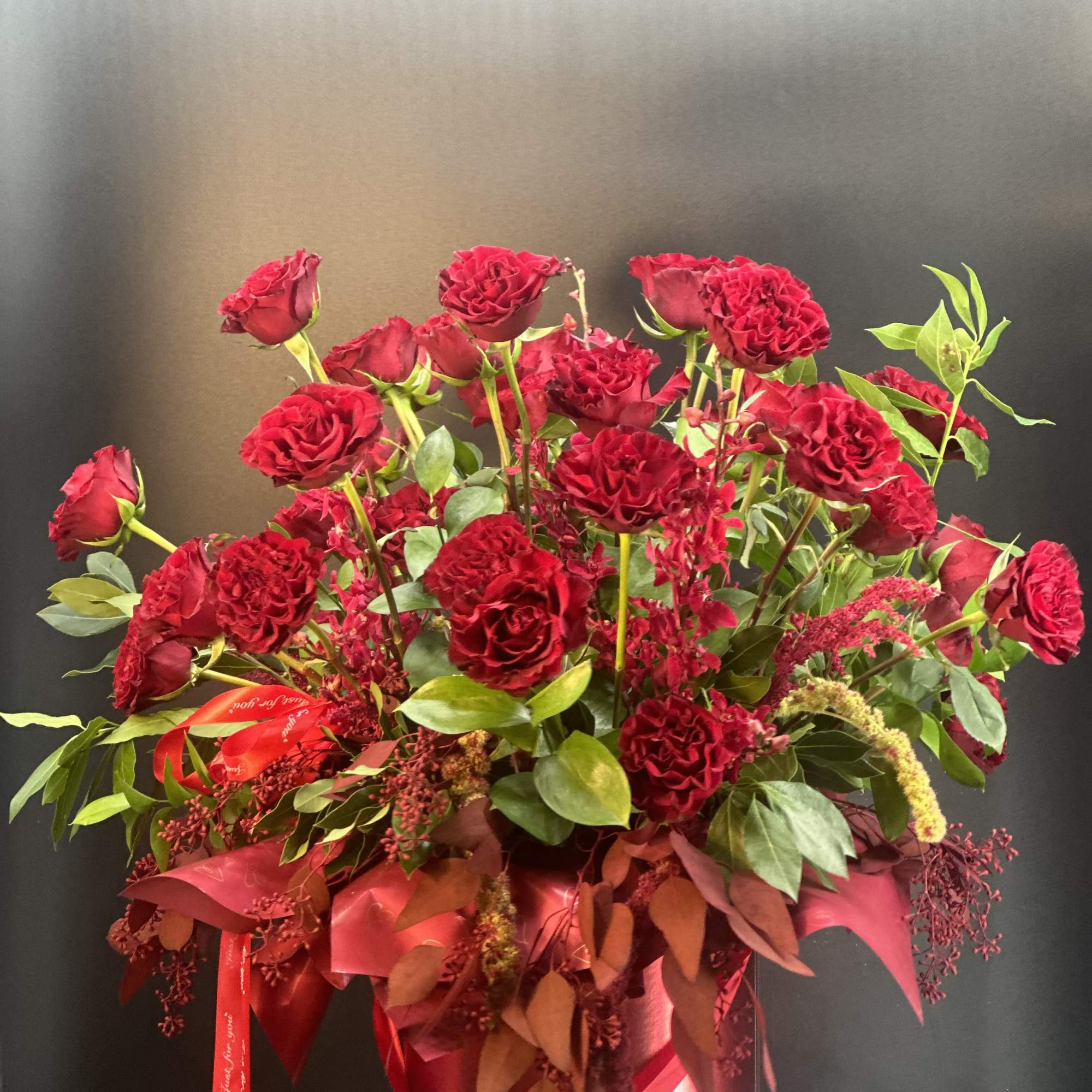 Red rose arrangement in a round box with ribbon