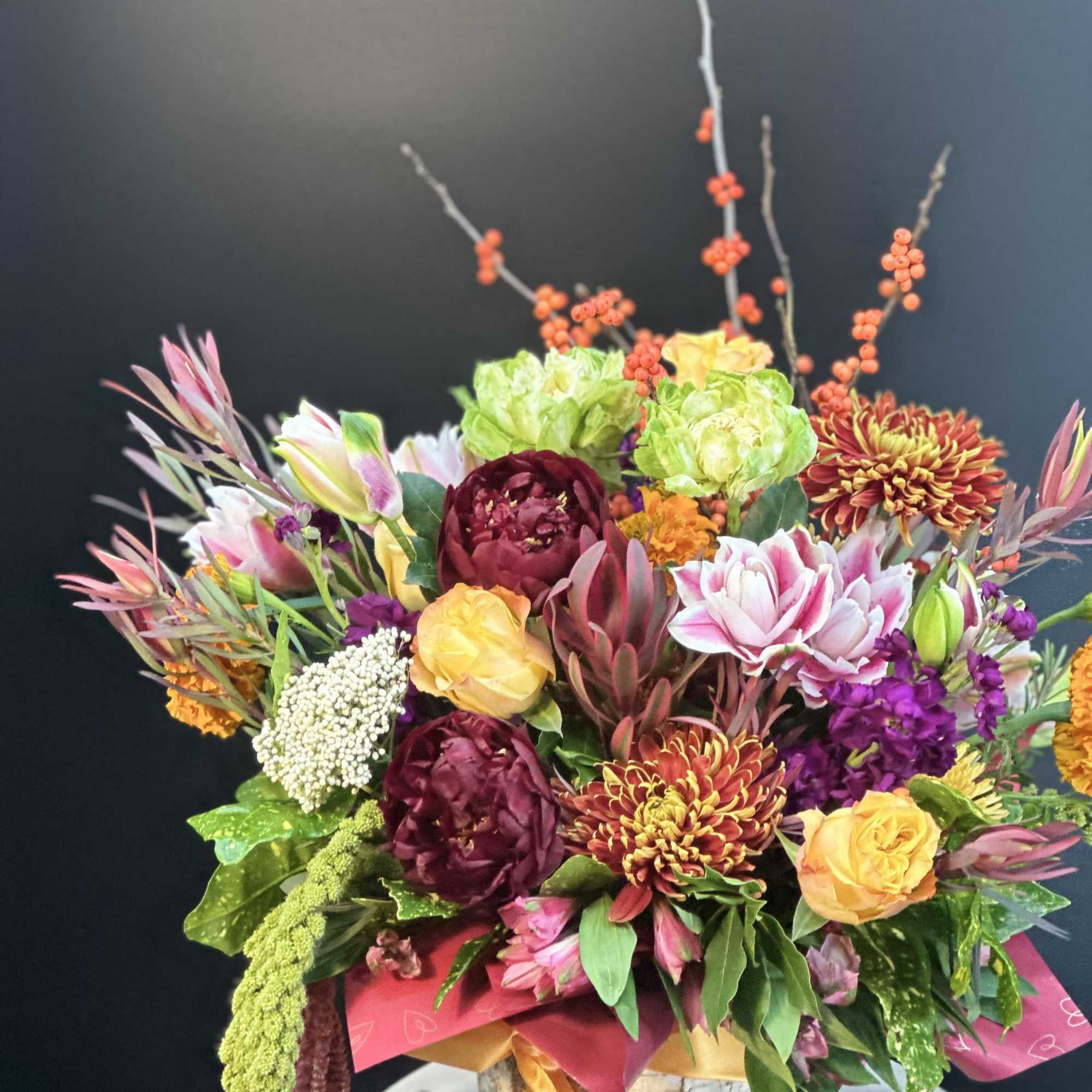 Colorful mixed flower arrangement in a birch-style container
