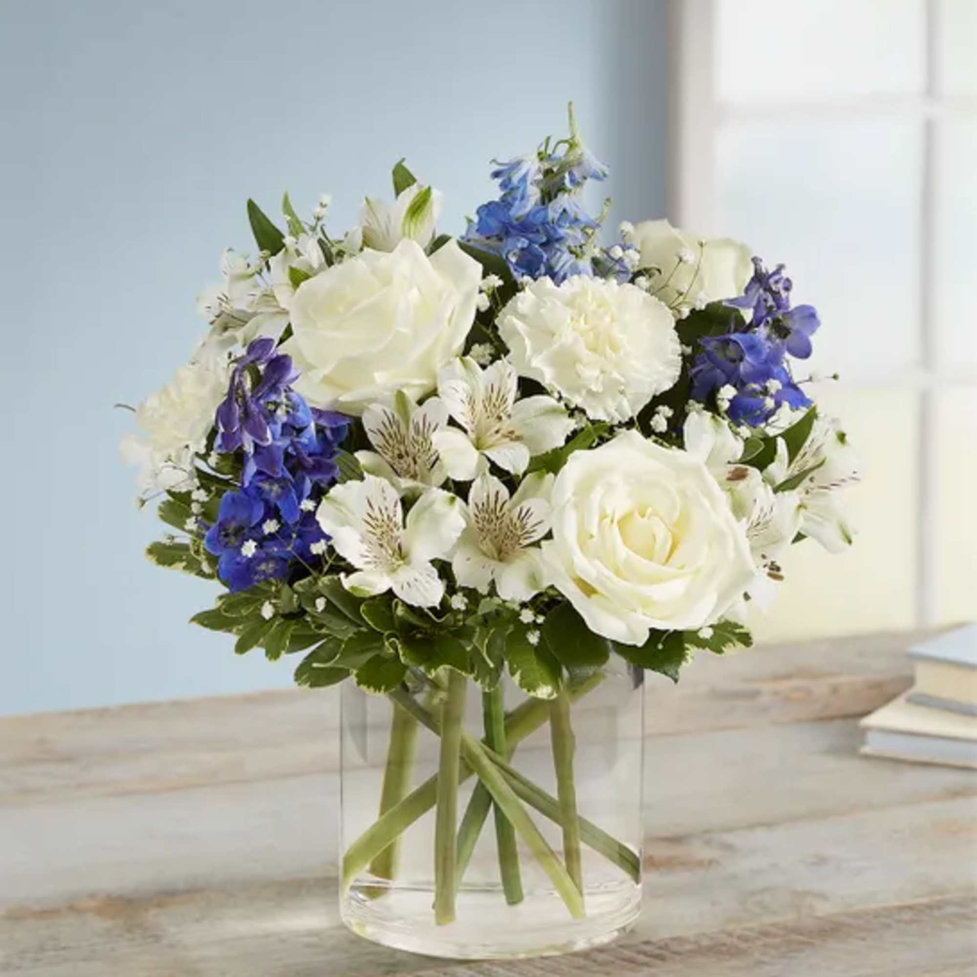 Blue delphinuium, white roses, white carns, white Astro, baby&rsquo; breath, and greenery