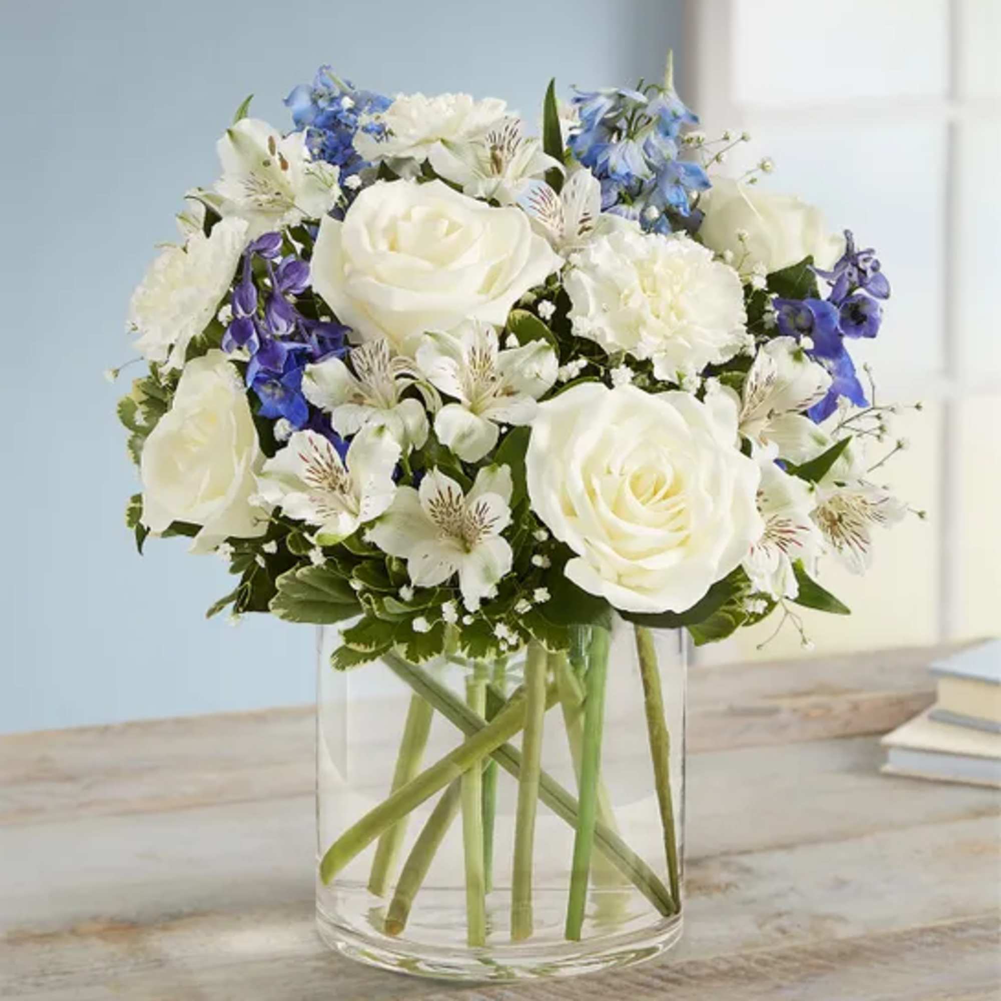 Blue delphinuium, white roses, white carns, white Astro, baby&rsquo; breath, and greenery