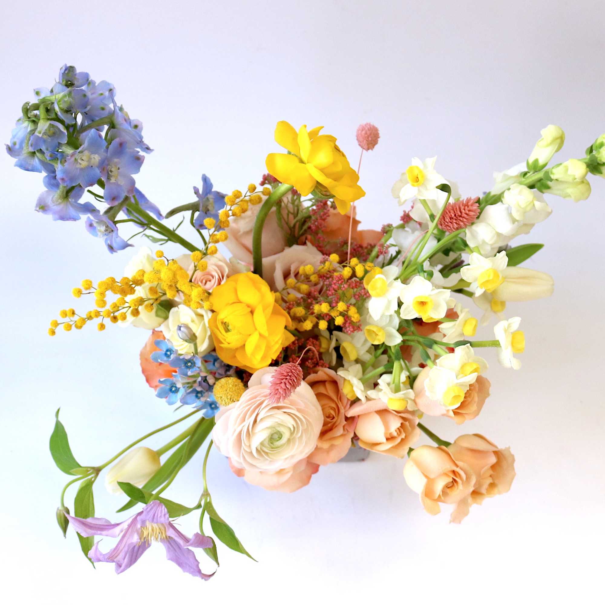 Colorful bouquet with yellow, peach, white, and blue flowers
