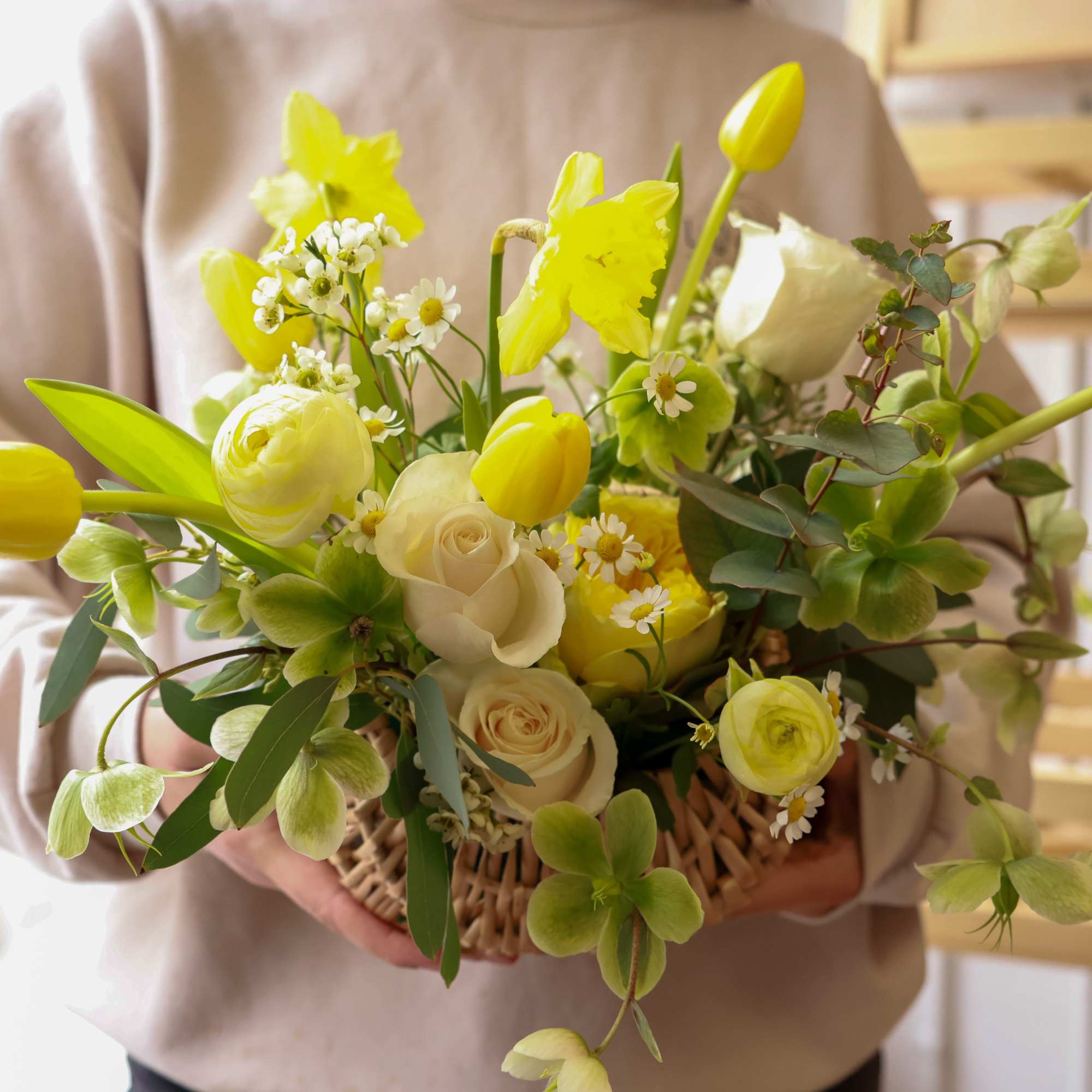 Yellow tulips and white roses in a woven basket