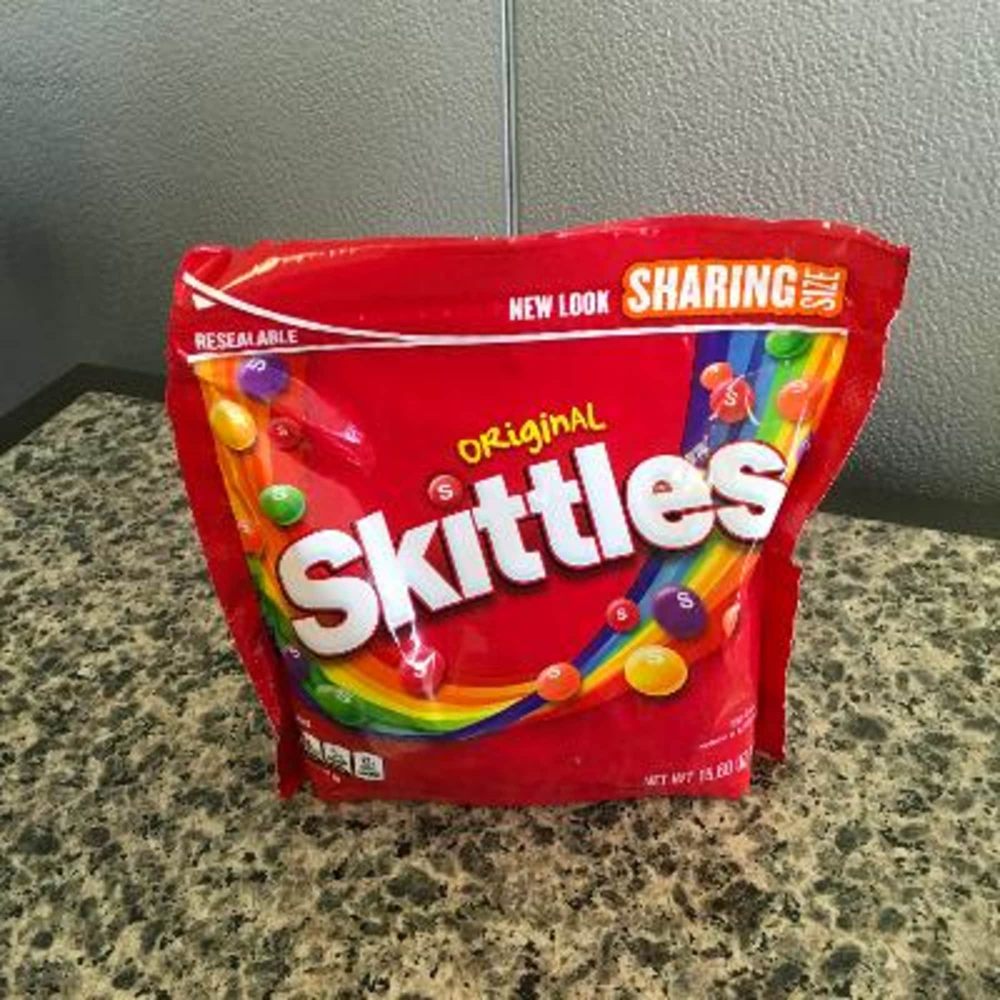 A red bag of Skittles candy on a countertop
