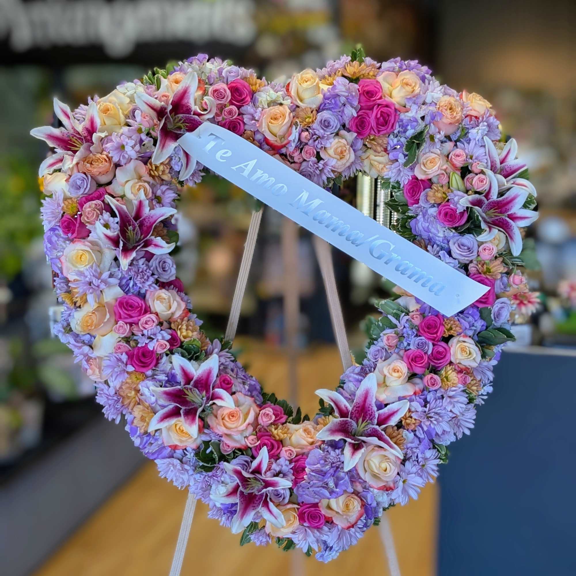 Heart-shaped floral wreath with pink, lavender, and cream blooms