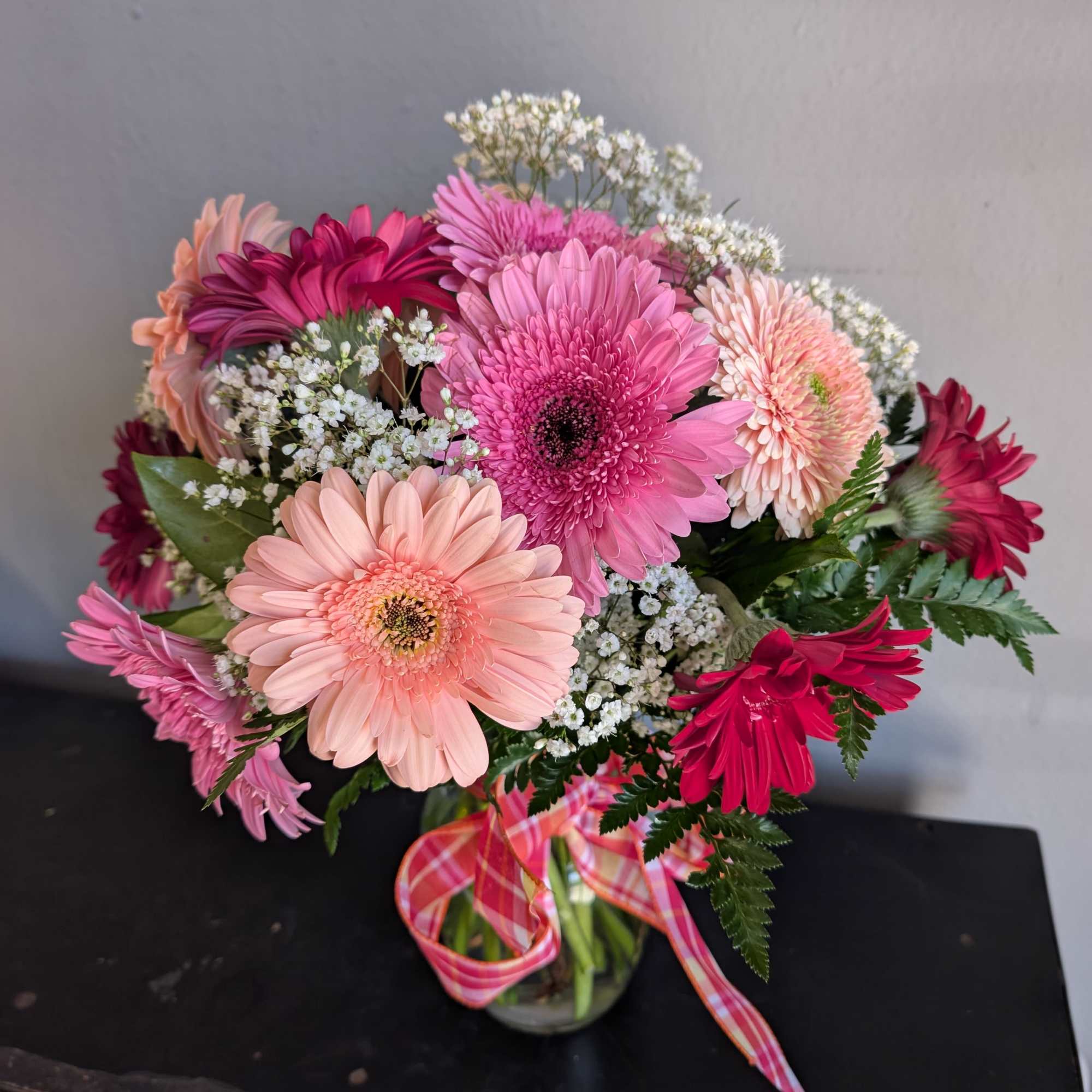 A lovely, cheerful mix of a dozen gerbera daisies and greens in