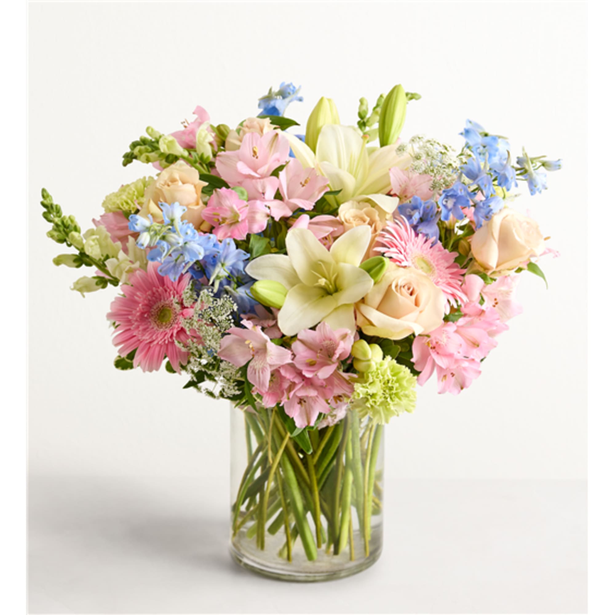 Mixed bouquet of pastel flowers in a clear glass vase