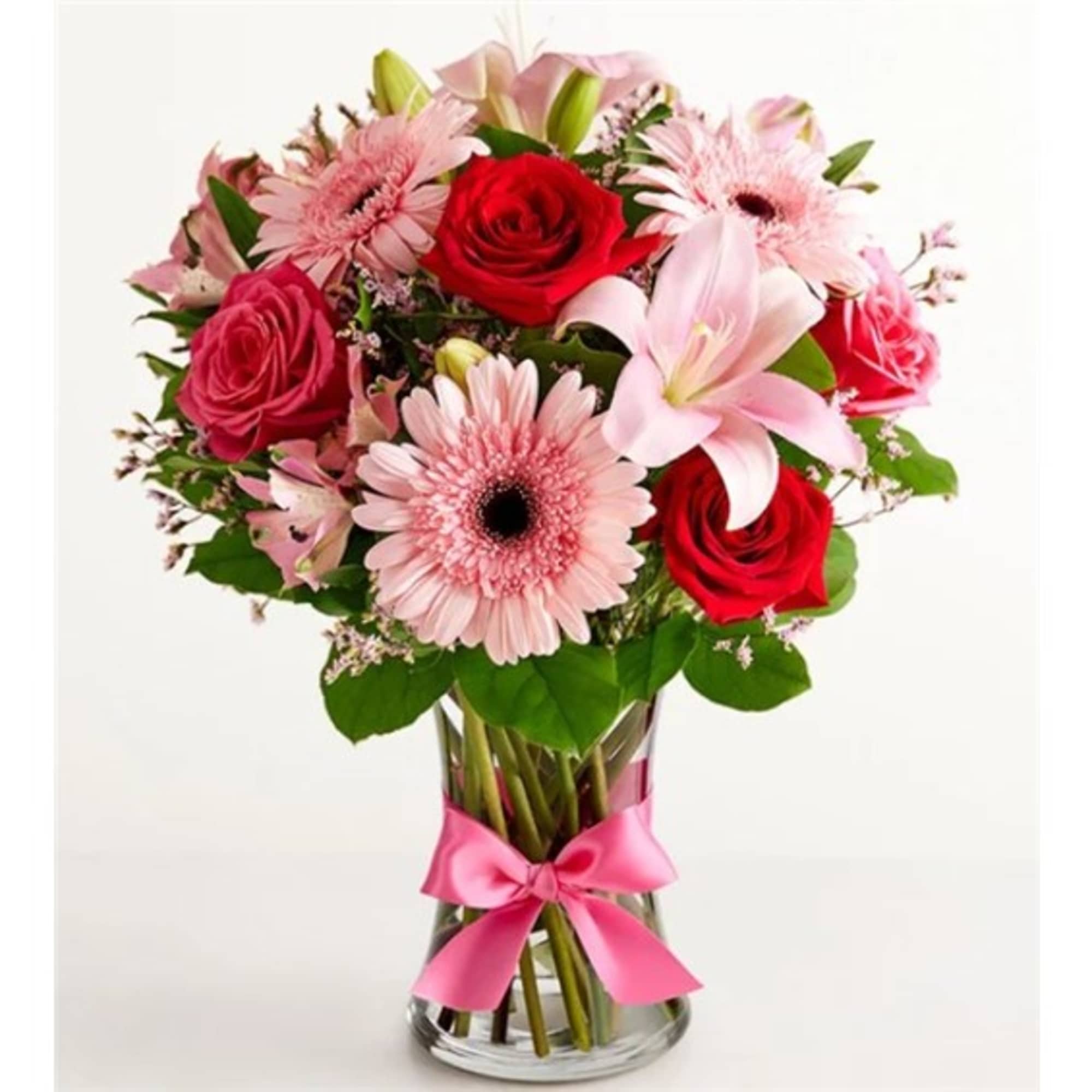 Pink and red mixed bouquet in a glass vase with a pink ribbon