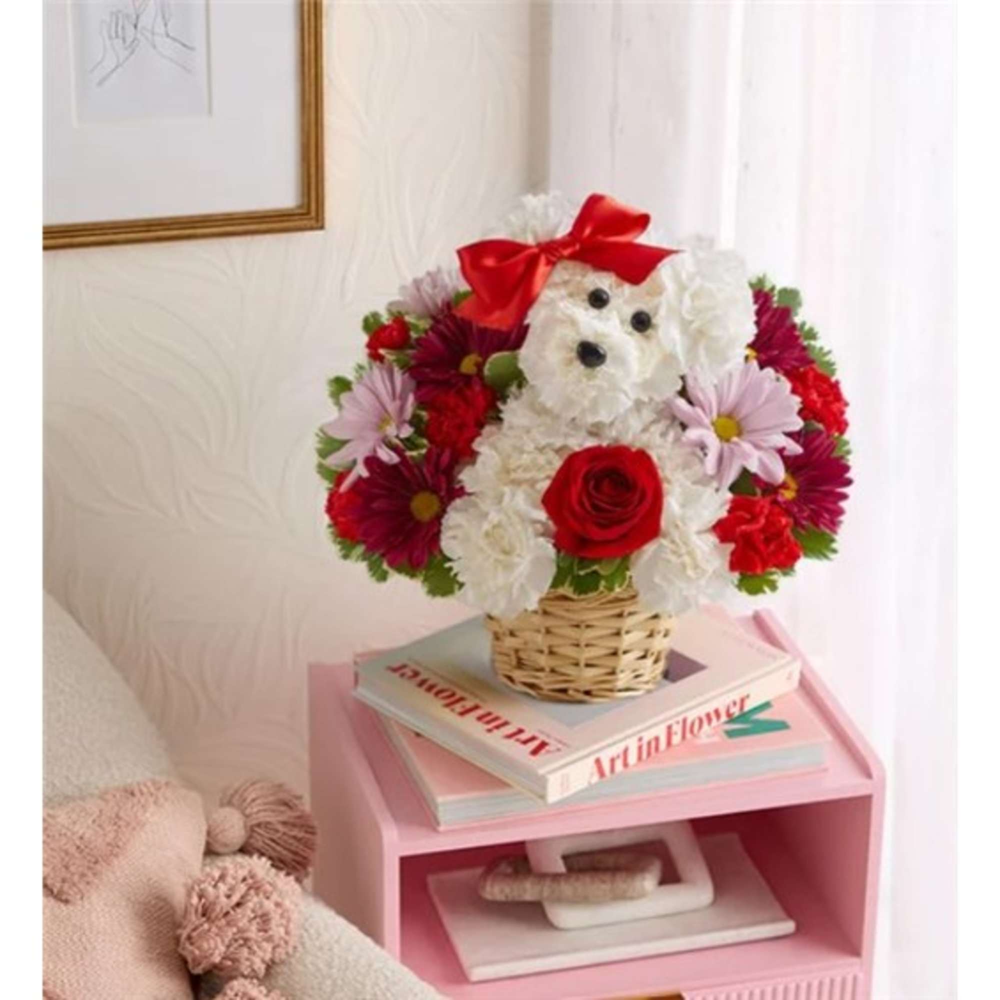 Flower arrangement shaped like a white dog in a basket with a red bow