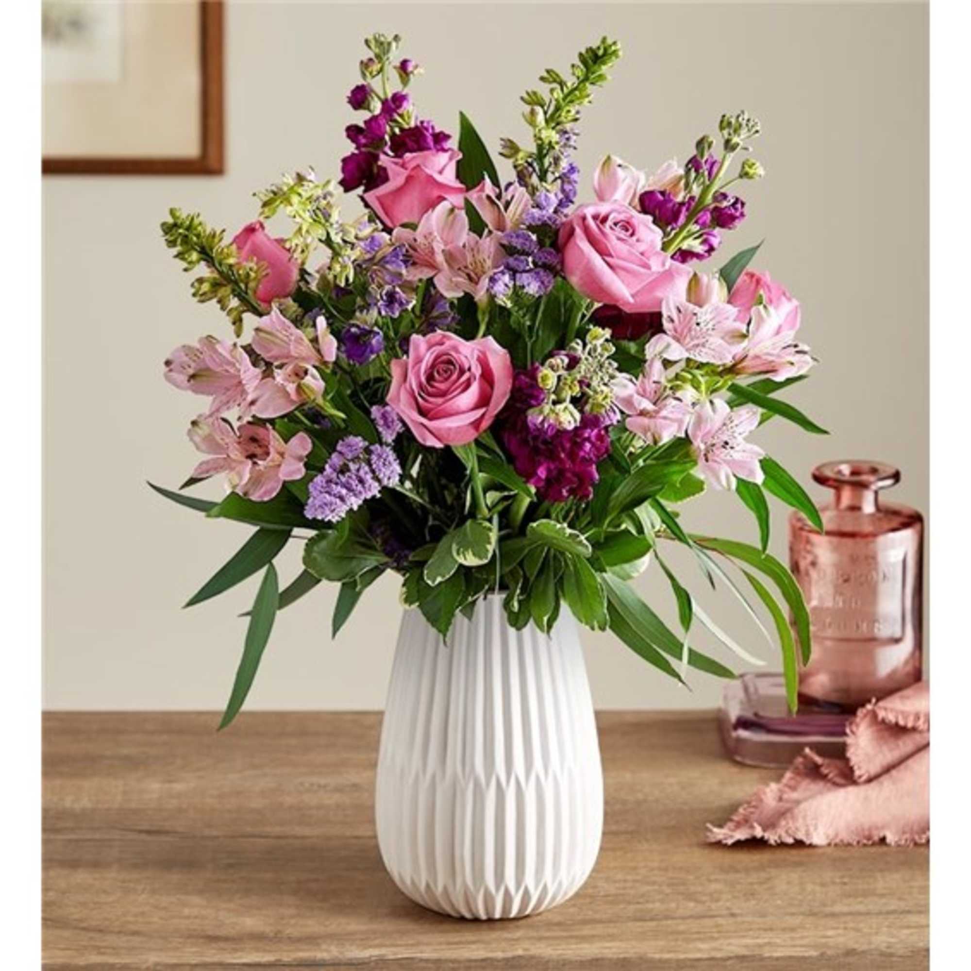 Pink and purple mixed flower arrangement in a white vase