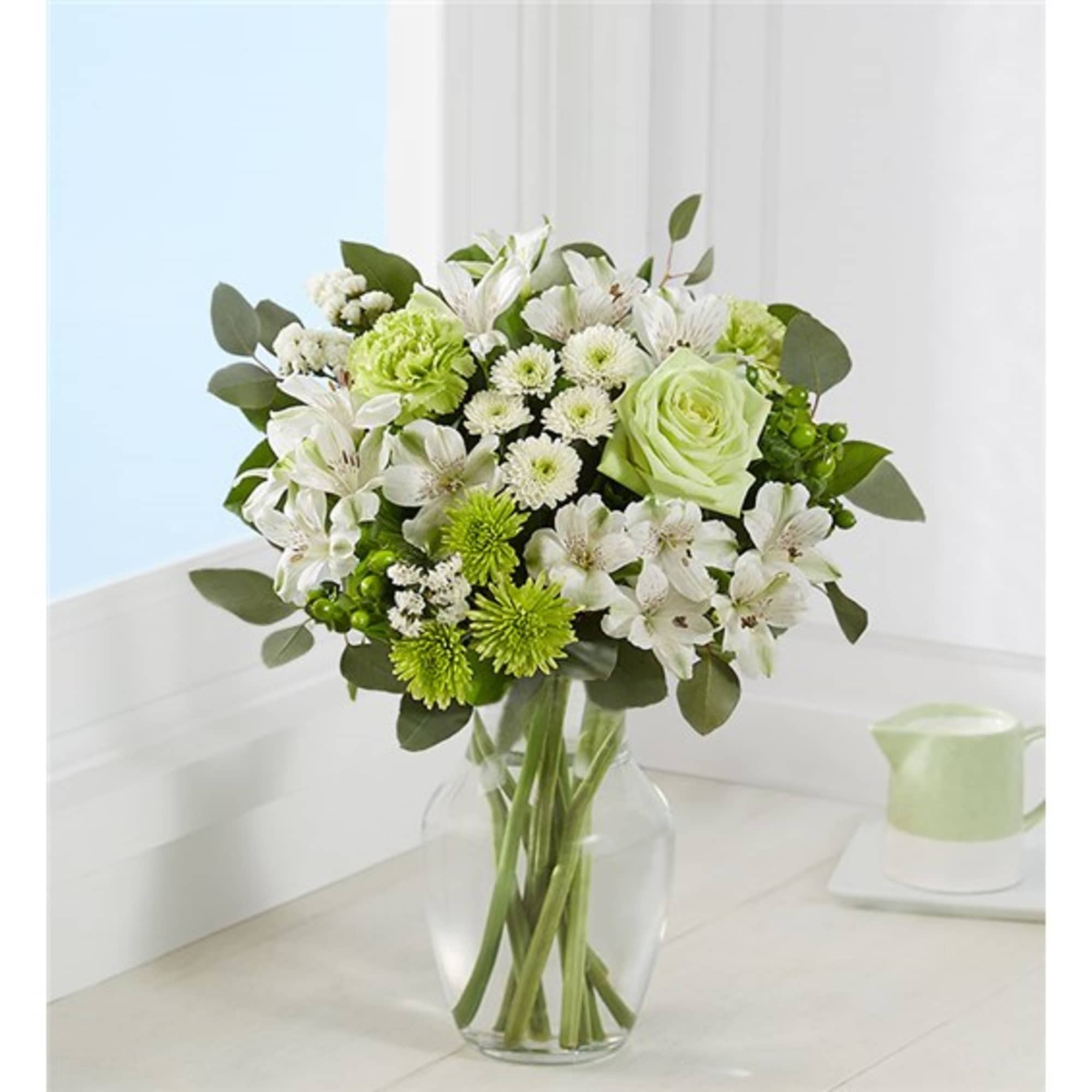 White and green bouquet in a clear glass vase