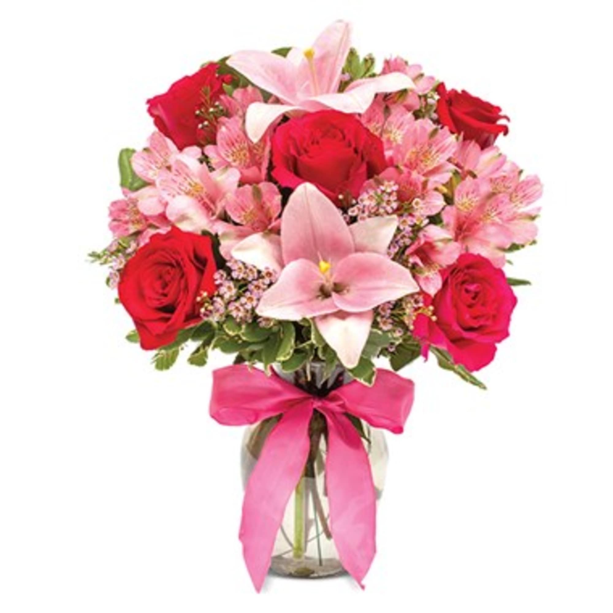 Bouquet of red roses and pink lilies in a glass vase with a pink ribbon