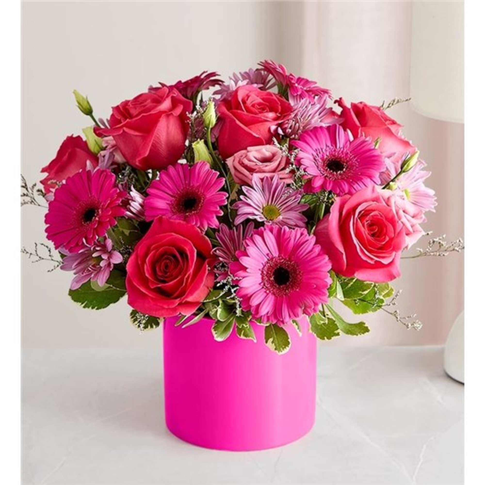 Pink roses and gerbera daisies in a bright pink vase