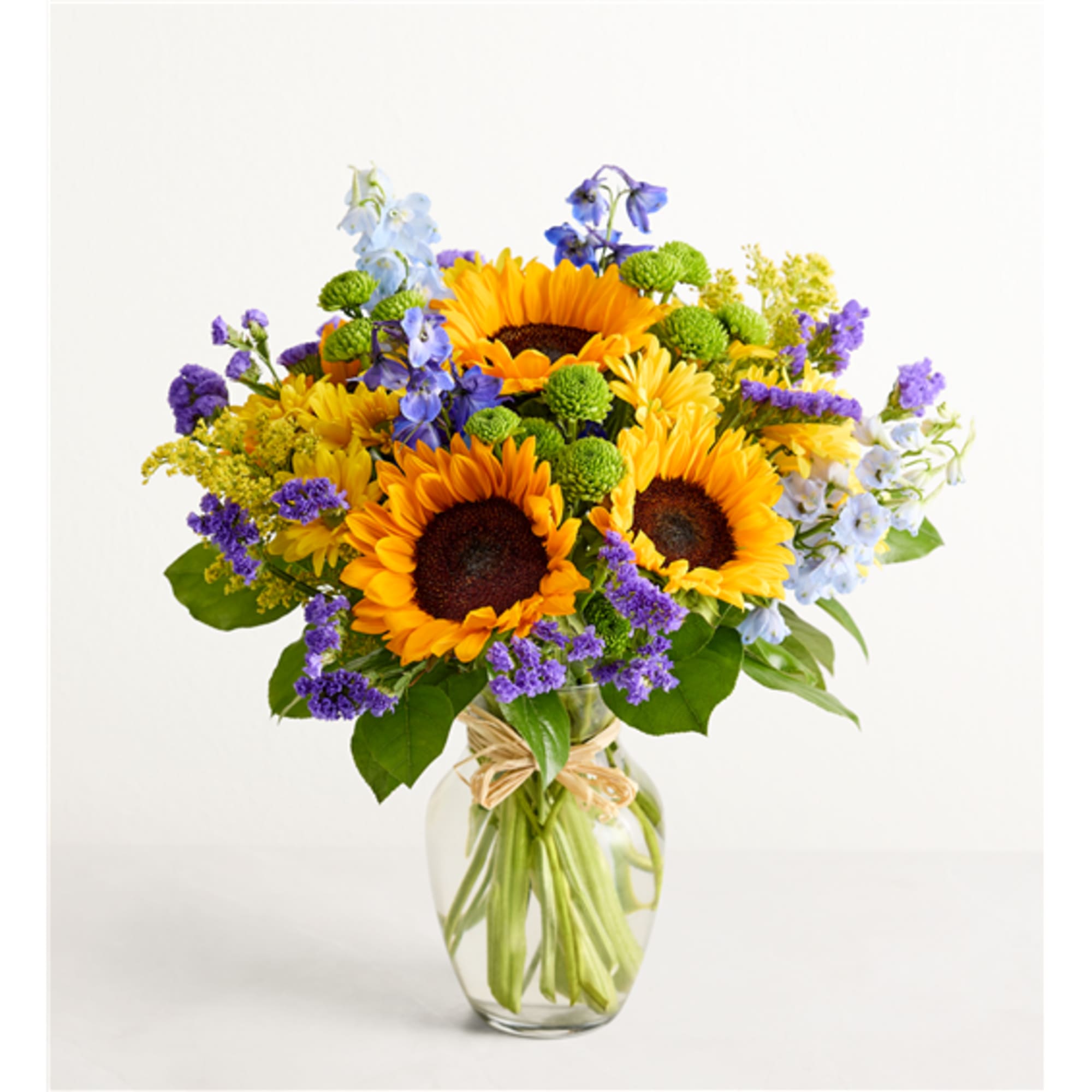 Sunflower bouquet in a clear glass vase with purple and blue flowers