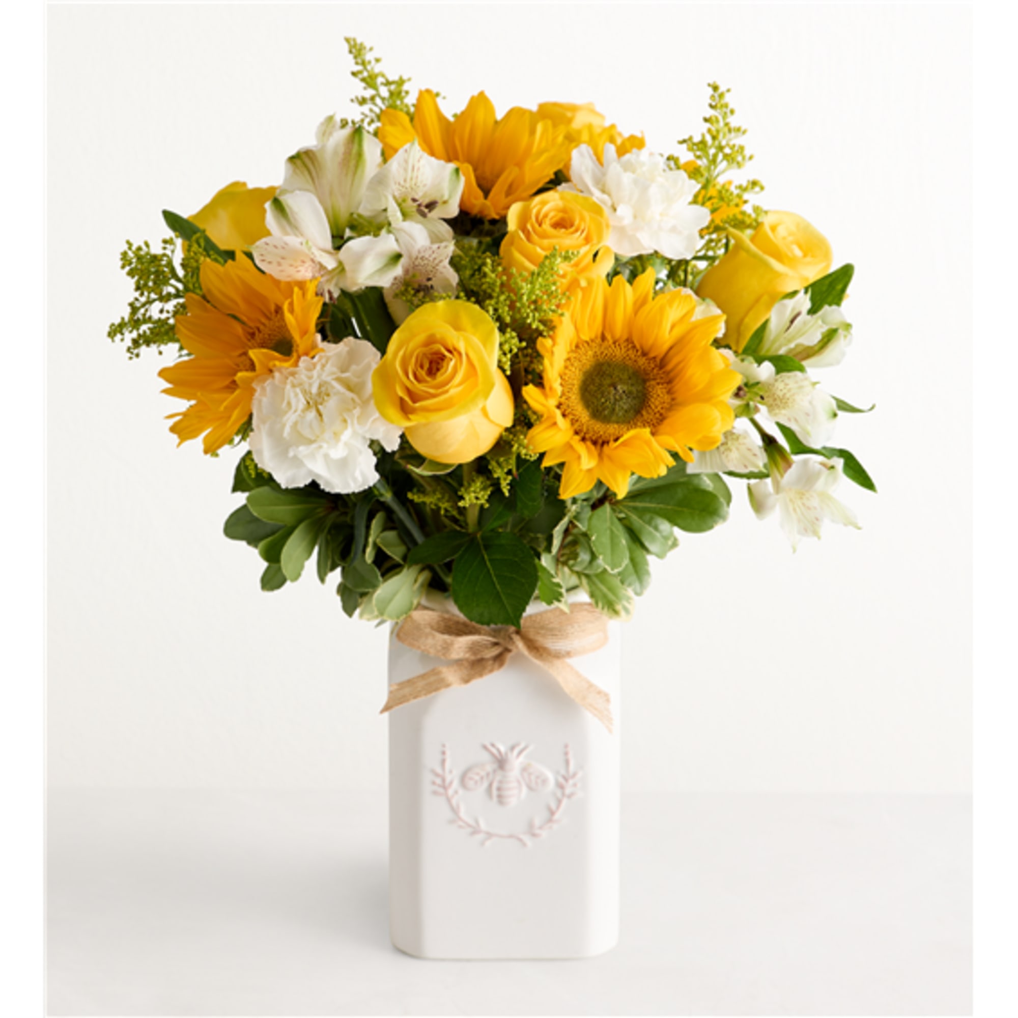 Yellow and white mixed bouquet in a white vase with a ribbon