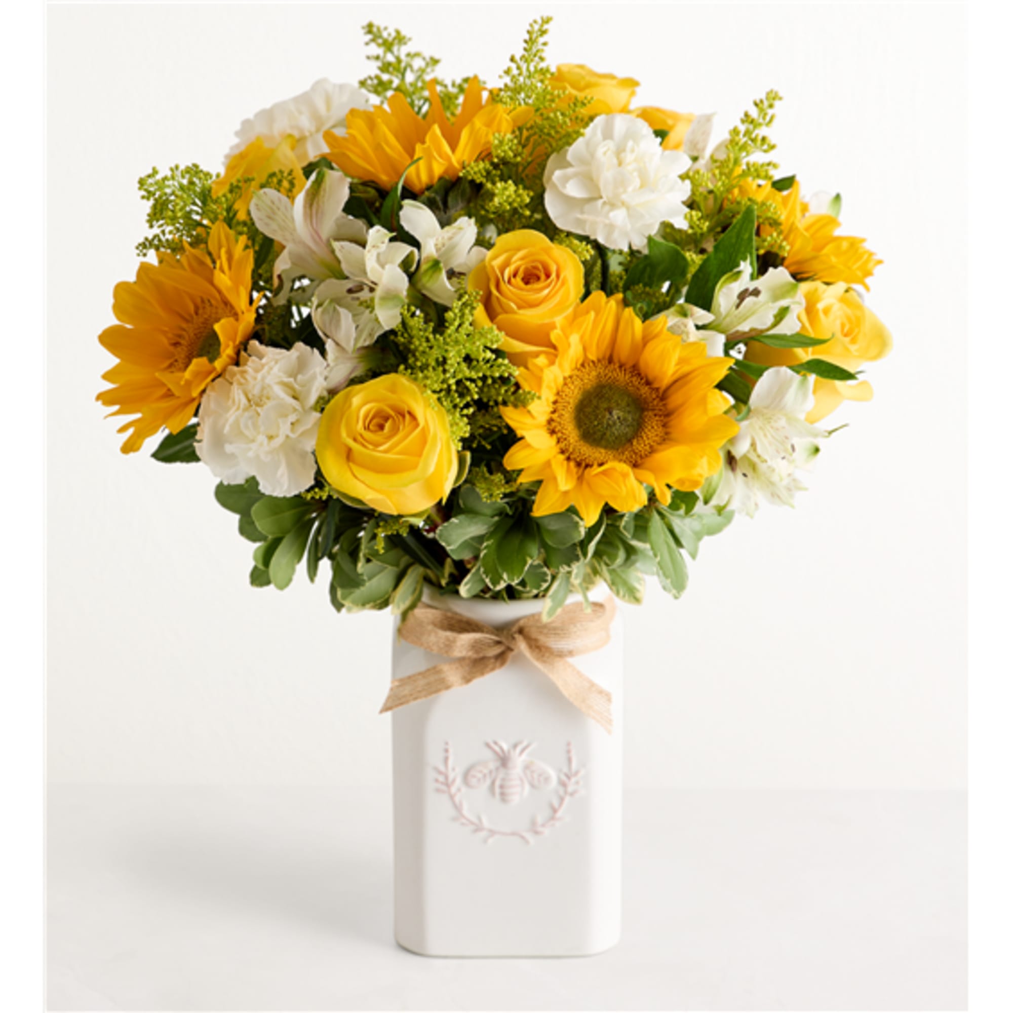 Yellow and white bouquet in a white vase with a ribbon