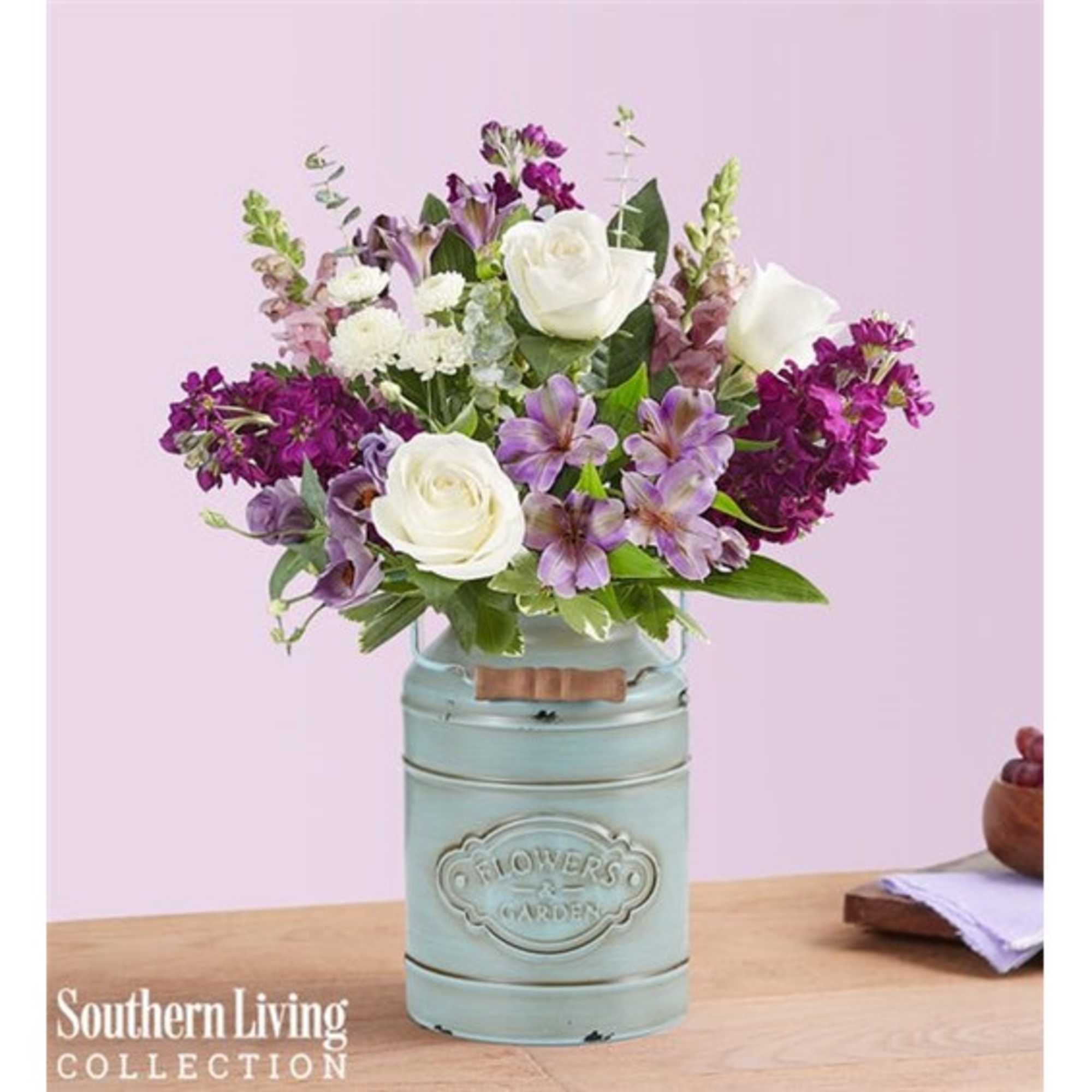 Bouquet of white roses and purple flowers in a pale blue metal container