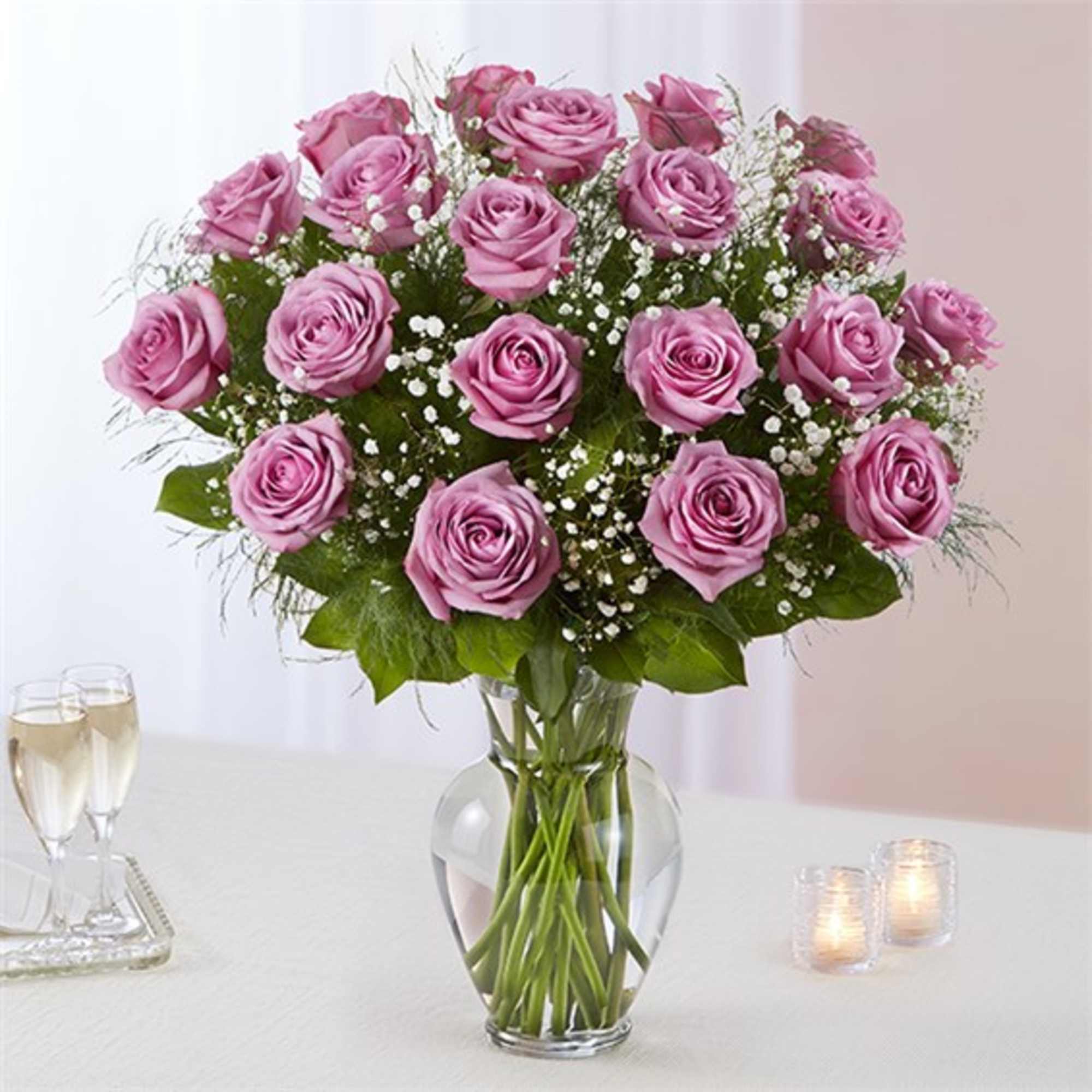 Pink rose bouquet in a clear glass vase with baby's breath