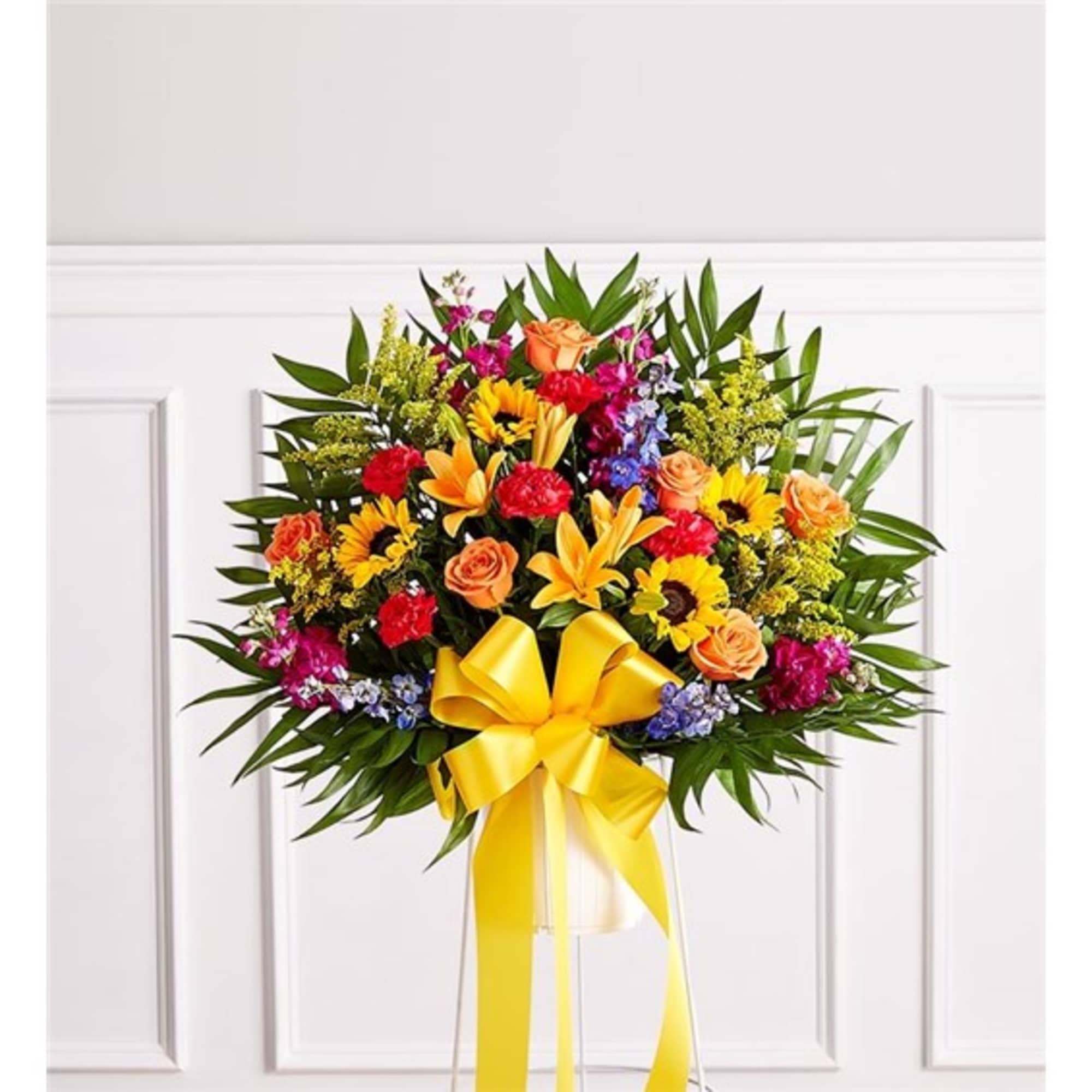 Colorful floral standing spray with a yellow ribbon bow
