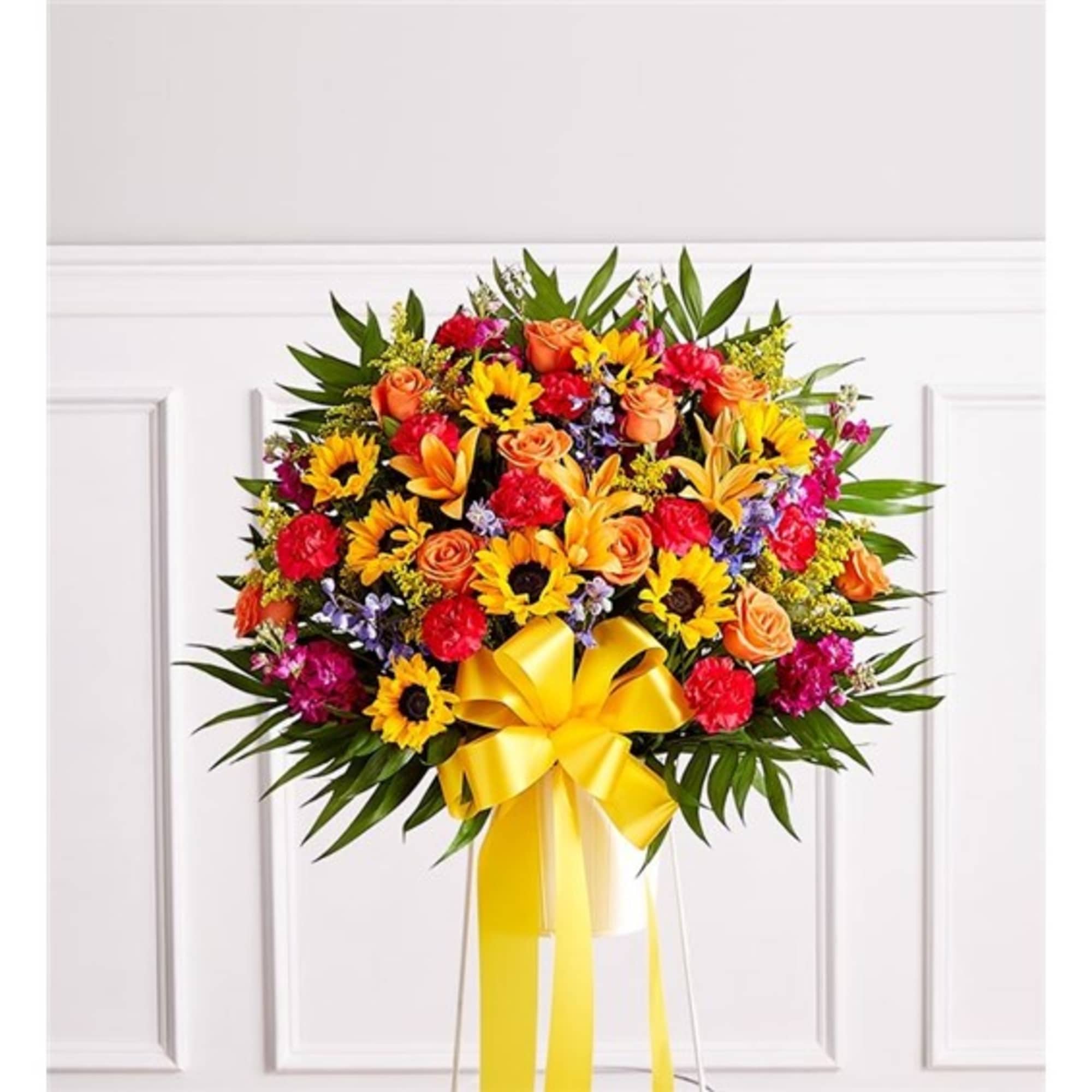 Bright mixed bouquet with sunflowers, roses, and lilies tied with a yellow bow