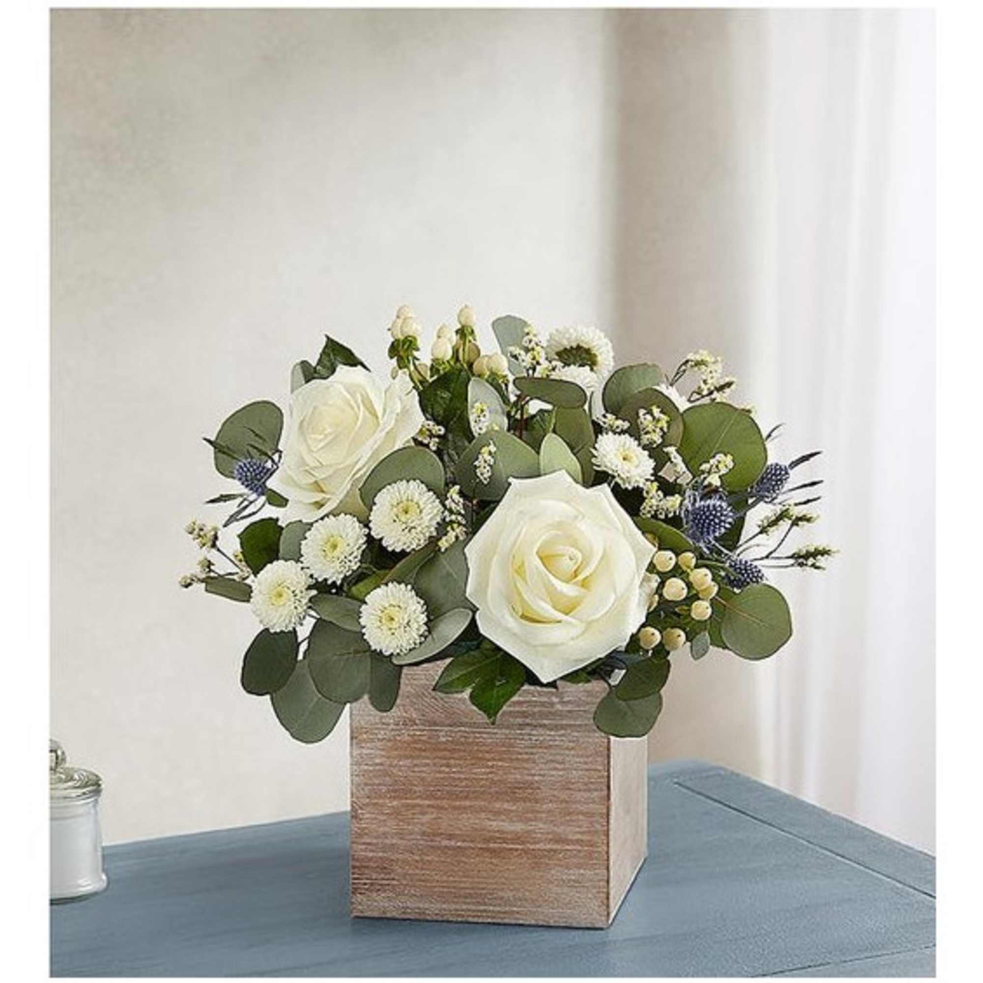 White roses and small white blooms in a wooden box