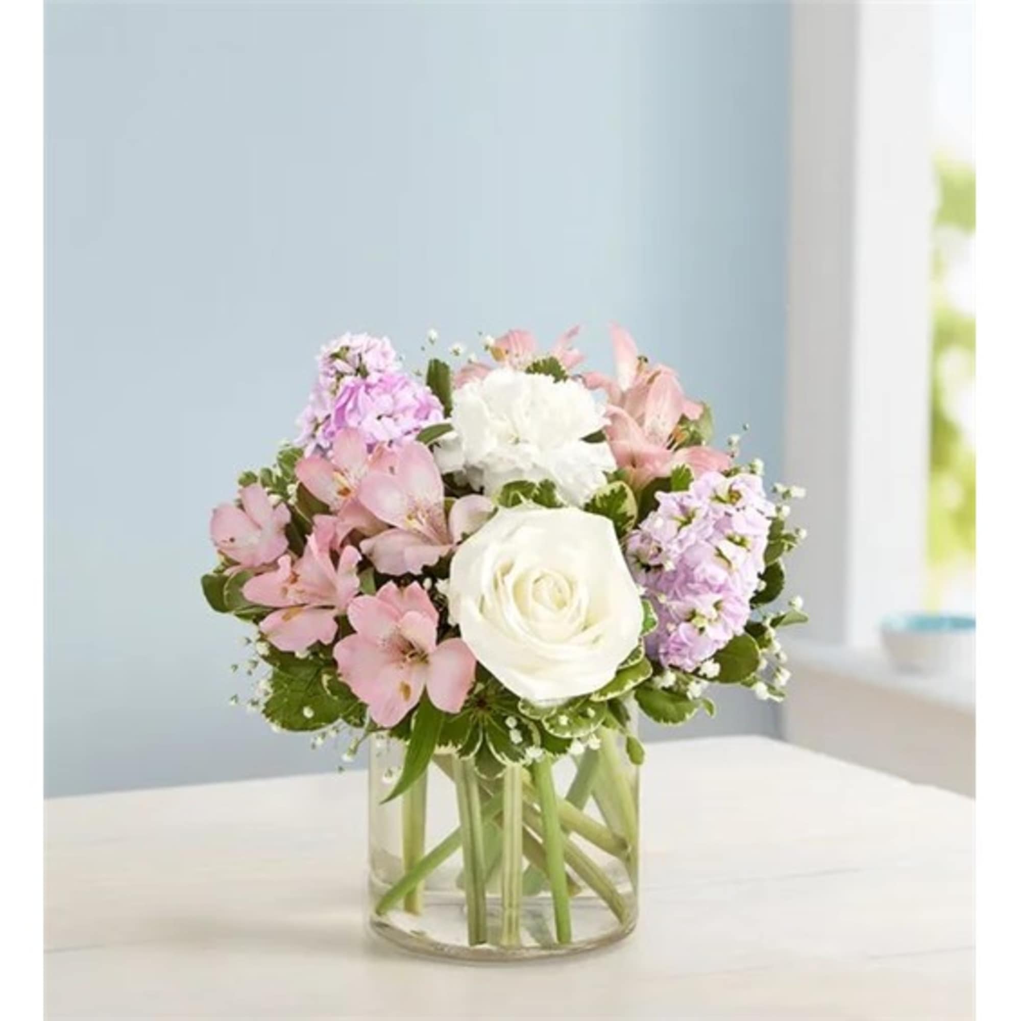 Pink and white flower arrangement in a clear glass vase