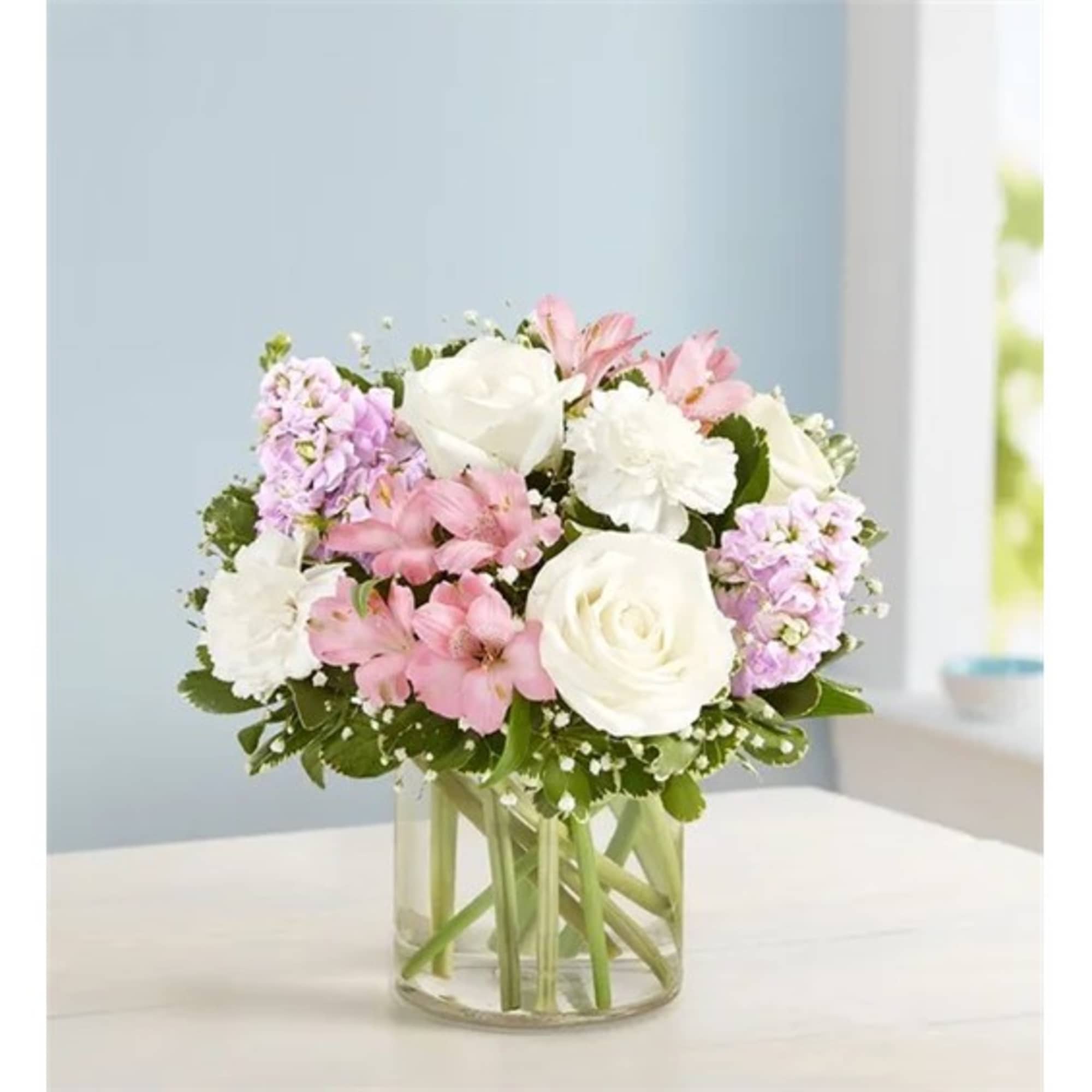 Pink and white flowers arranged in a clear glass vase