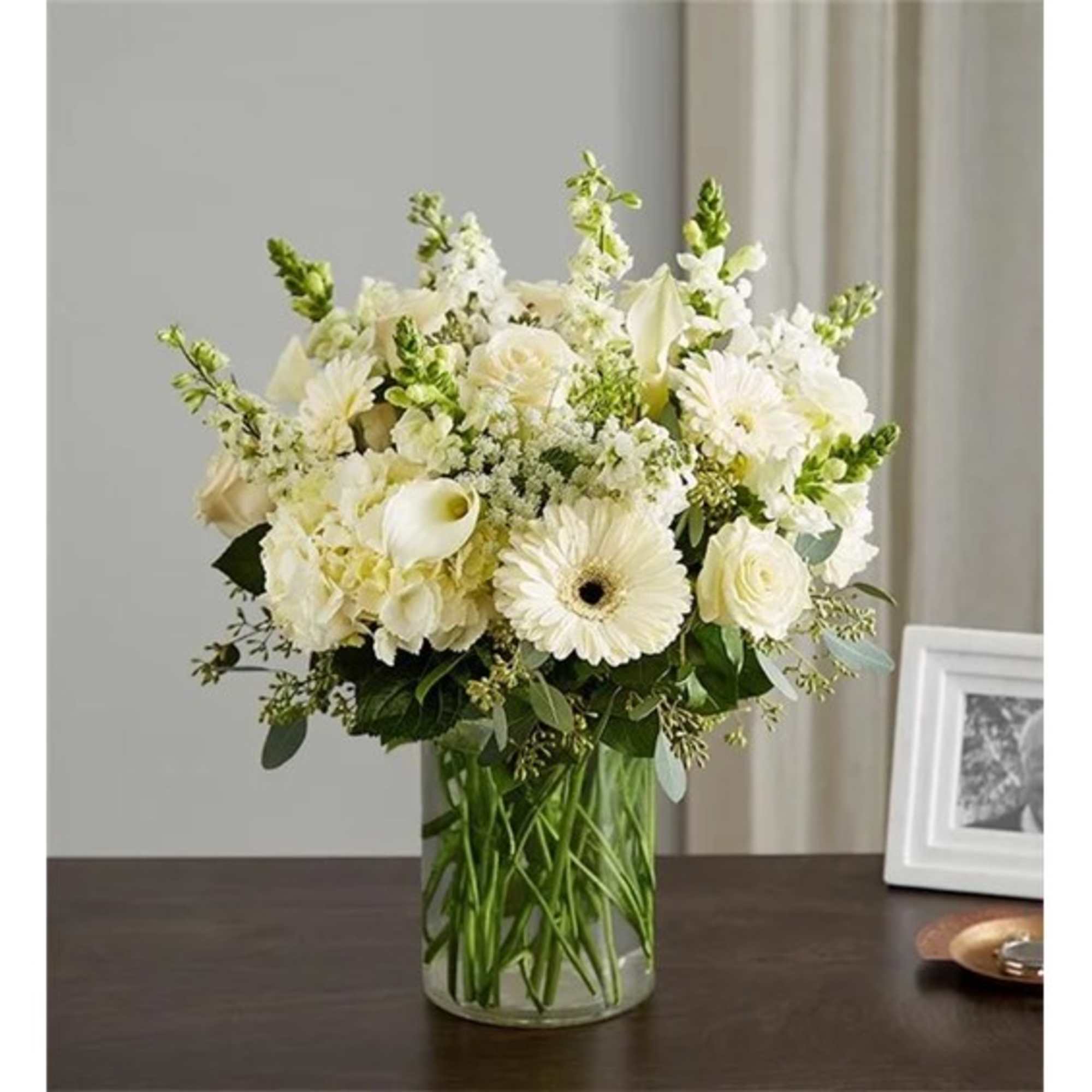 White flowers arranged in a clear glass vase on a table