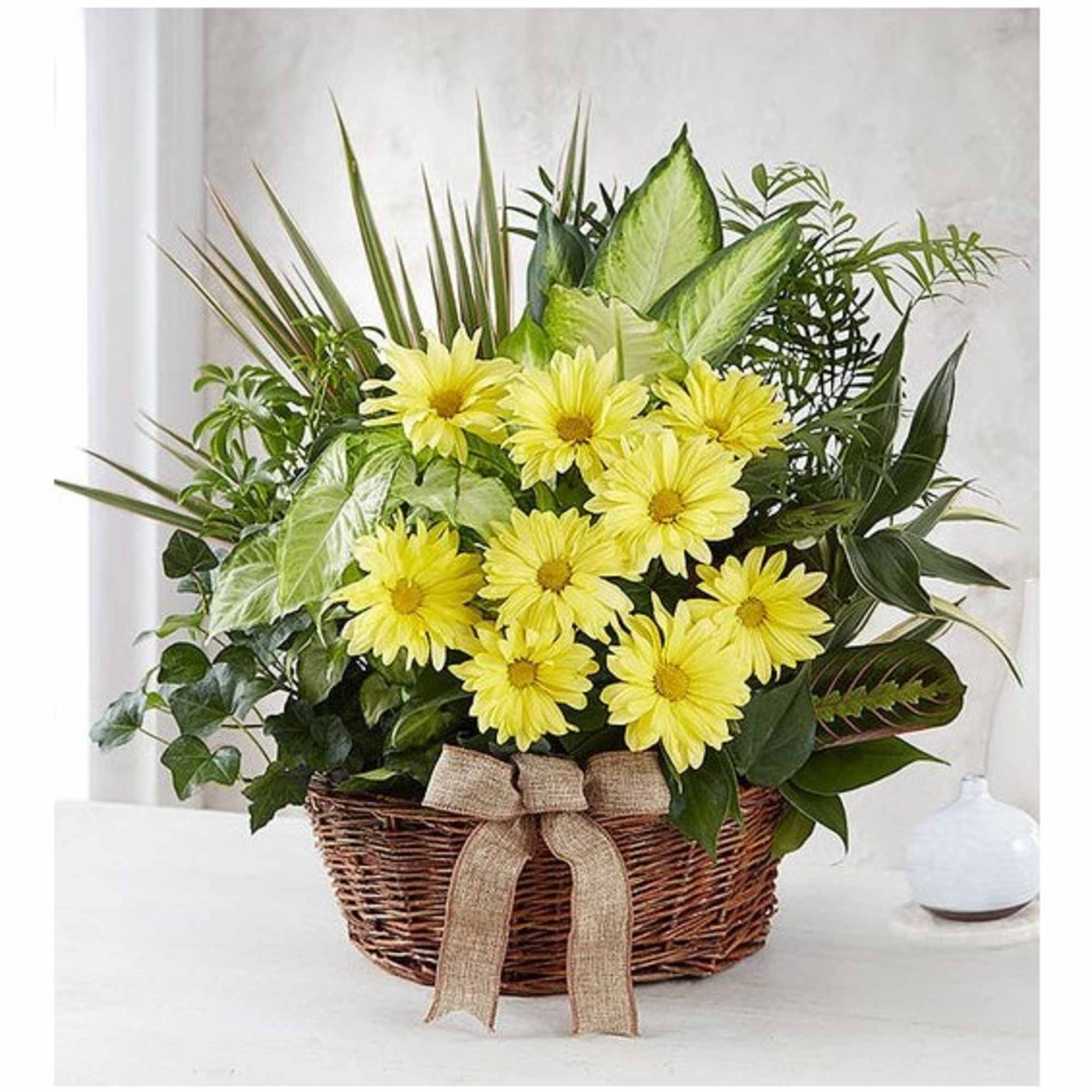 Yellow daisy bouquet in a wicker basket with a burlap bow