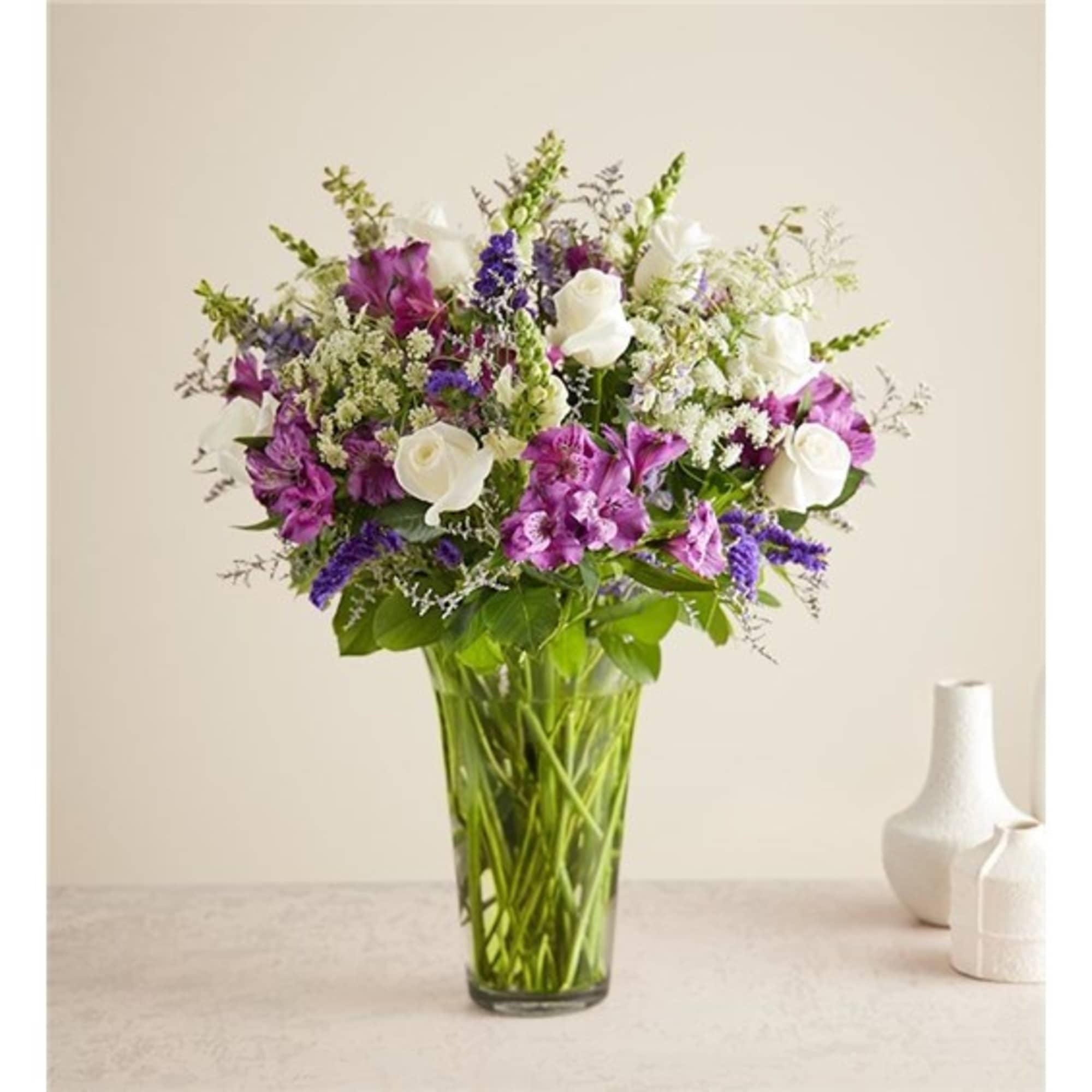 Purple and white mixed bouquet in a clear glass vase