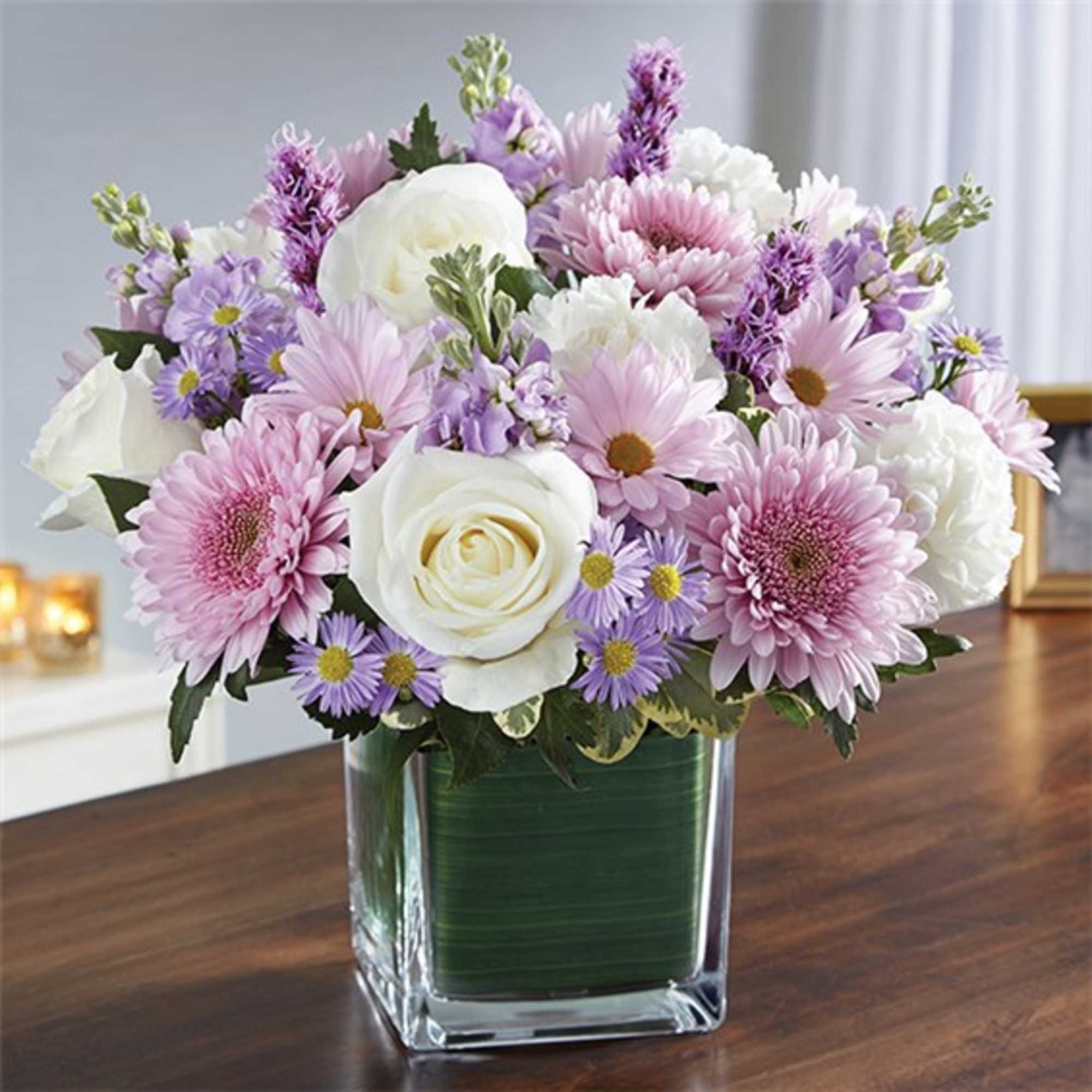 Pink and white mixed flowers in a clear square vase