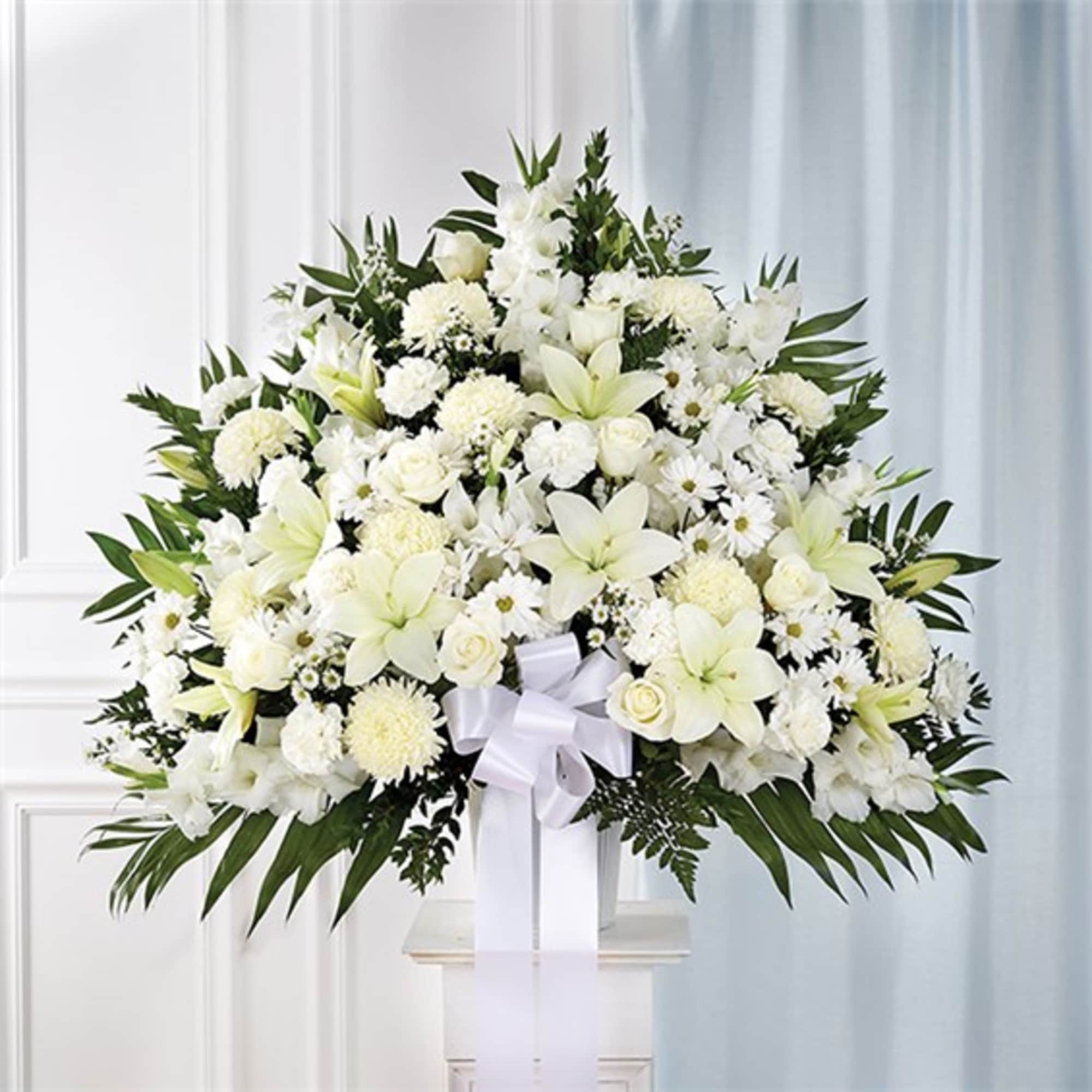 Large white floral spray with lilies and chrysanthemums on a stand