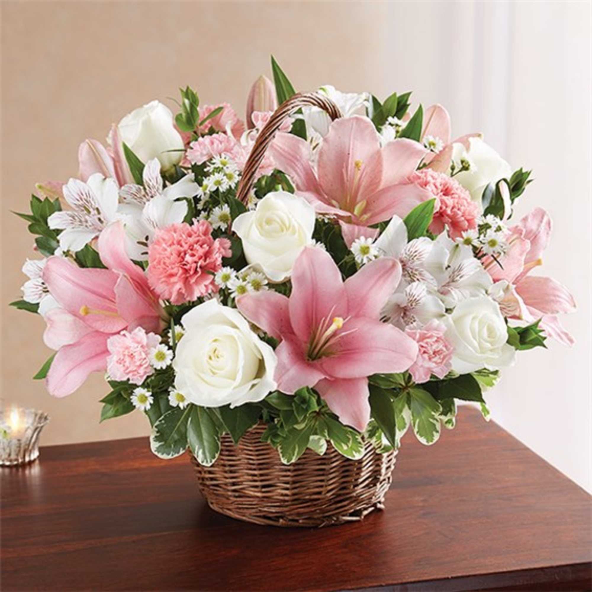 Pink and white flowers arranged in a wicker basket