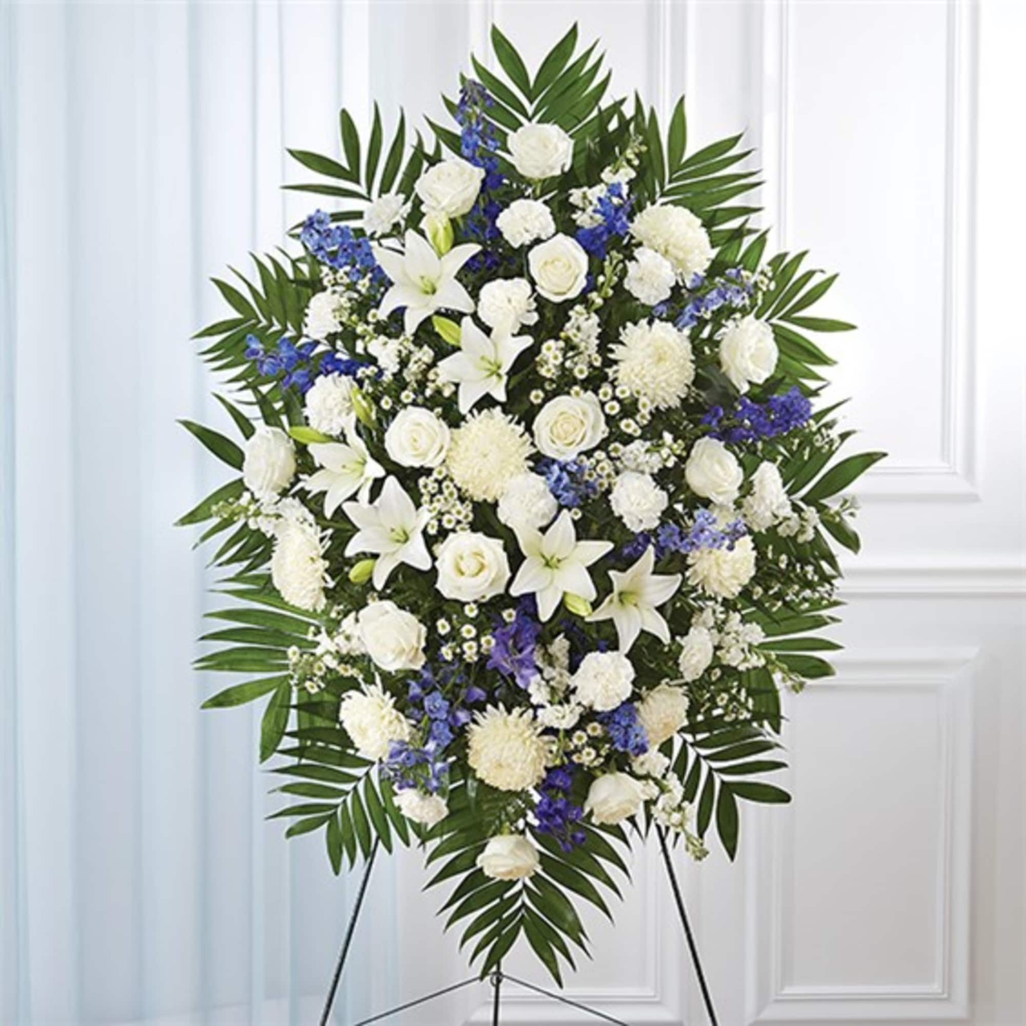Standing floral spray of white and blue flowers on an easel